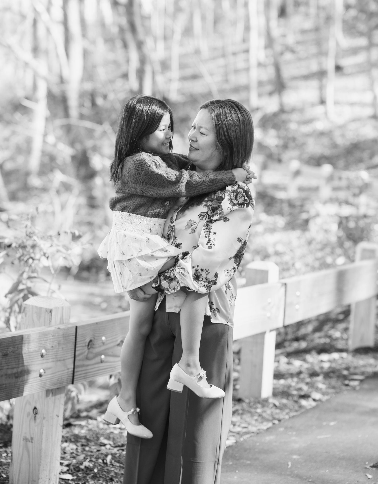Black and white portrait of family members sharing a moment outdoors.