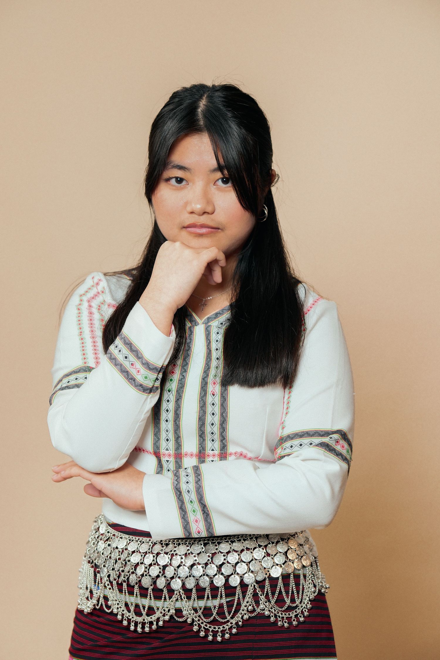 Model in traditional clothing shows contemplative poses against neutral background.