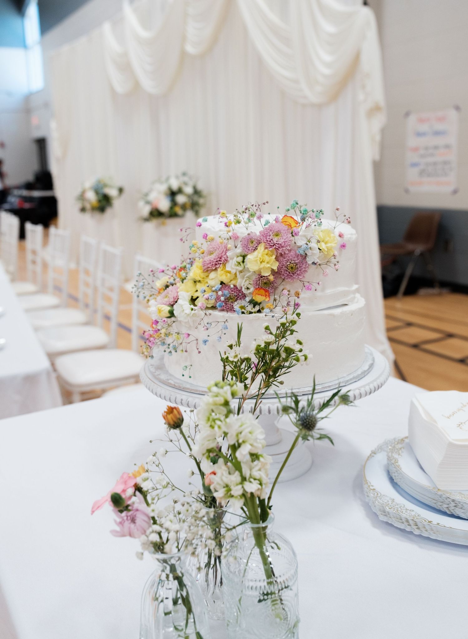 Elegant wedding reception tables with white linens and delicate wildflower centerpieces.