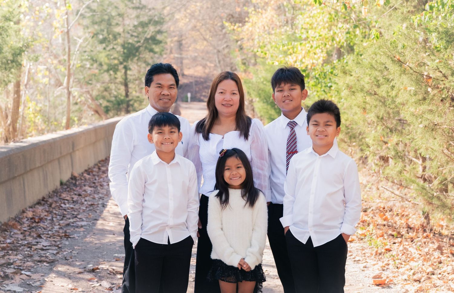 Group in matching formal wear posing together on an outdoor trail.