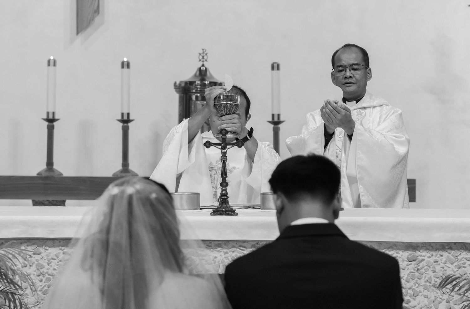 A solemn church wedding ceremony captured in black and white photography.