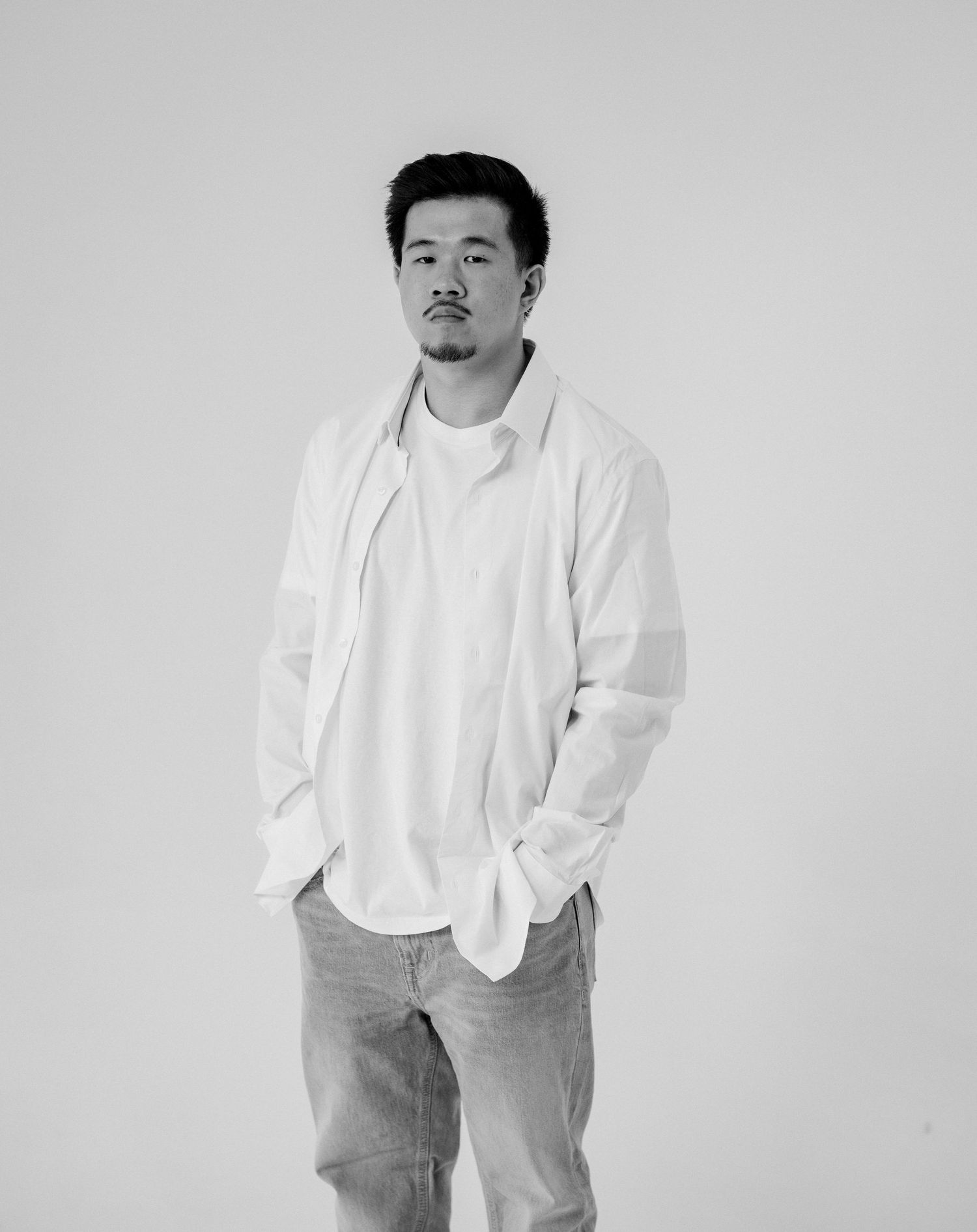 A minimalist black and white portrait series showing playful poses against a light background.