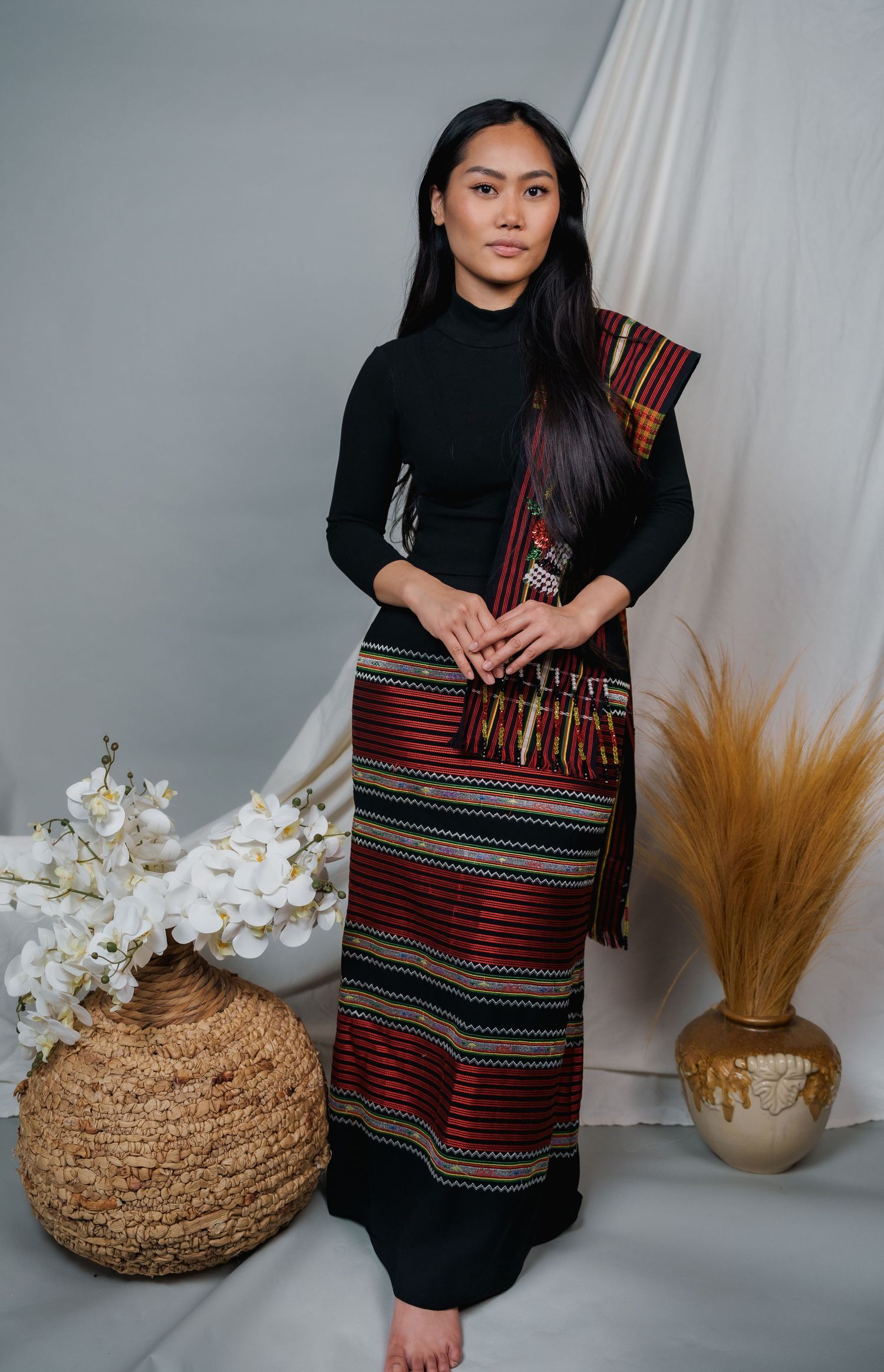 Traditional ethnic fashion display with woven bags and dried floral decorations.
