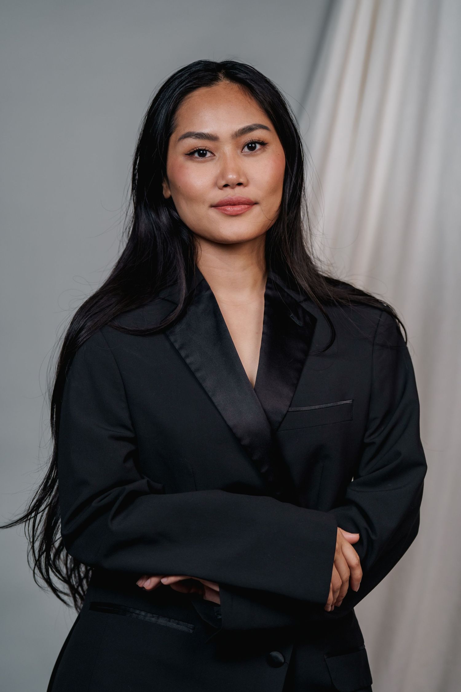 Dramatic black blazer fashion series with dynamic poses against light studio backdrop.