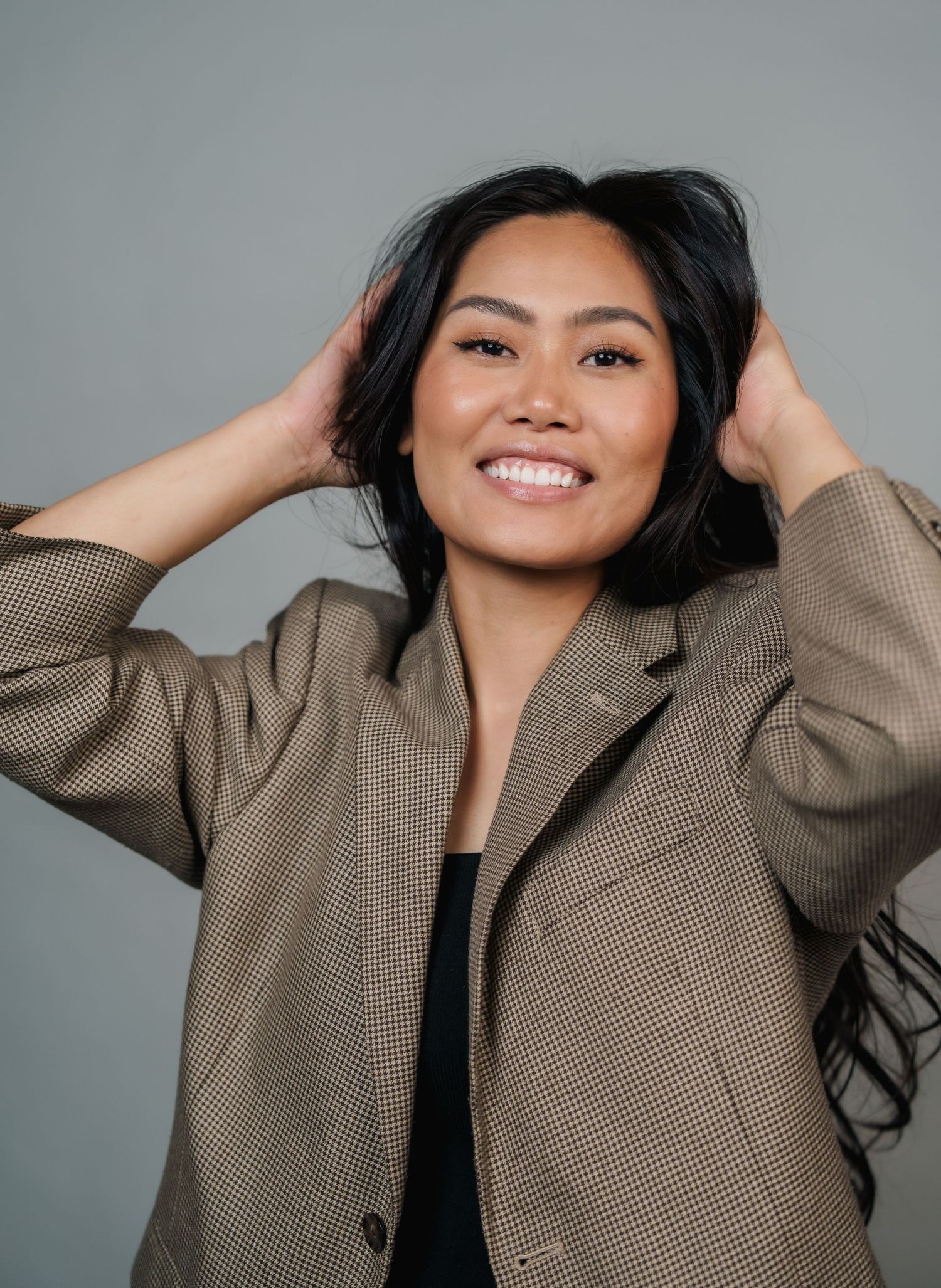 Playful fashion portraits featuring a tan plaid blazer and casual poses against neutral backdrop.