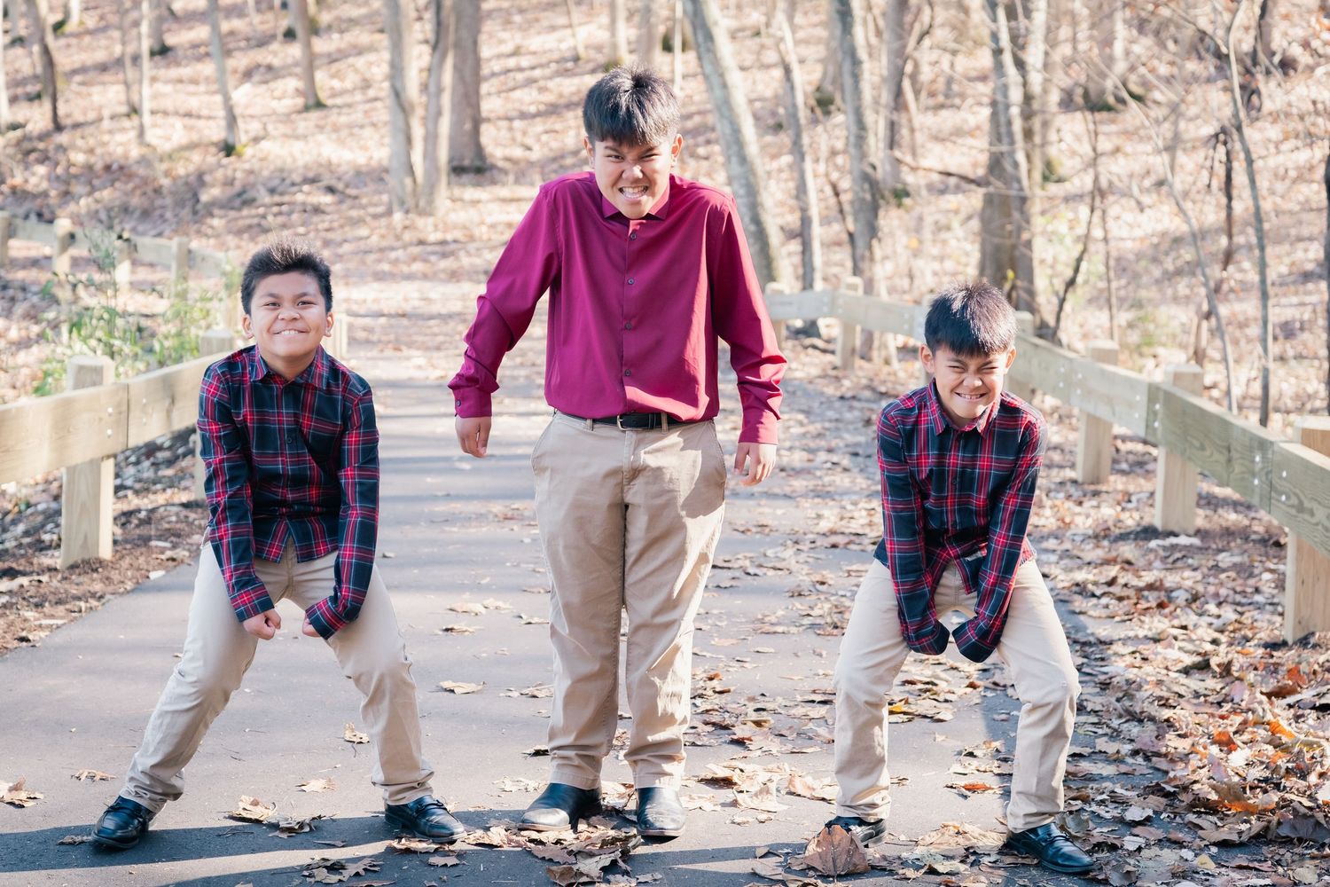 Playful siblings enjoying outdoor activities on a wooded path.