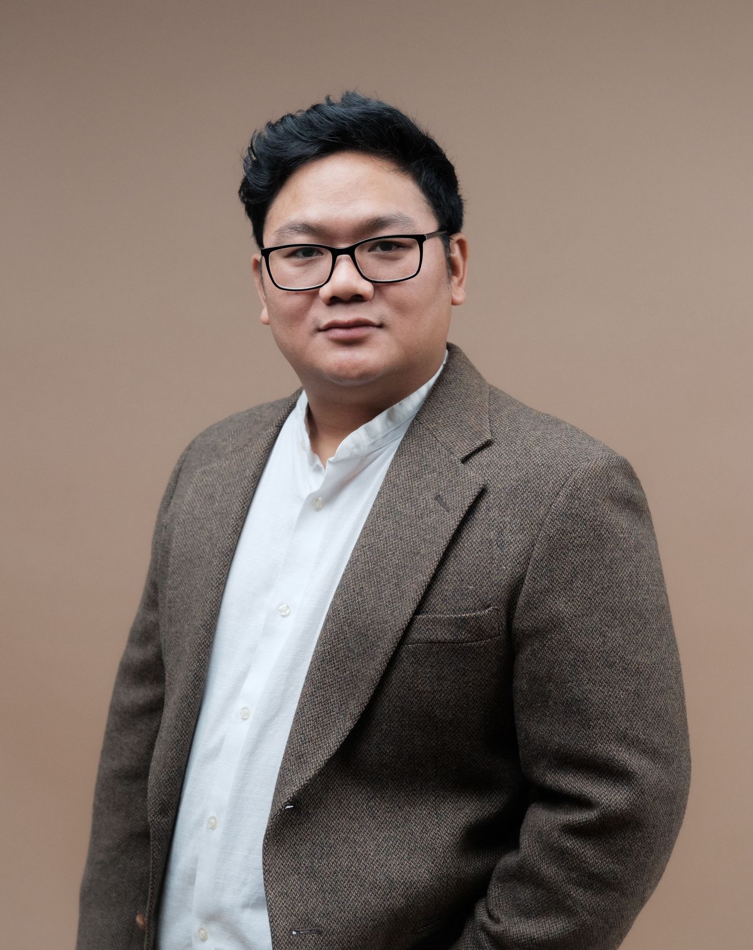 Professional studio portrait series in grey tweed blazer and white shirt.