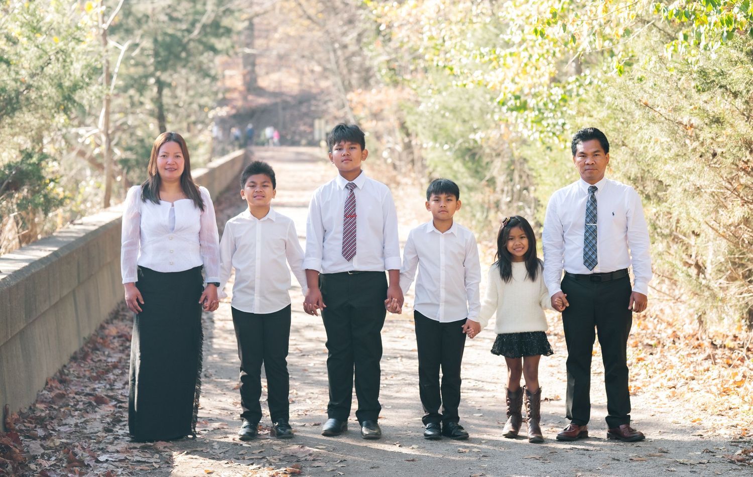 Group photo of people in coordinated black and white outfits on a scenic trail.