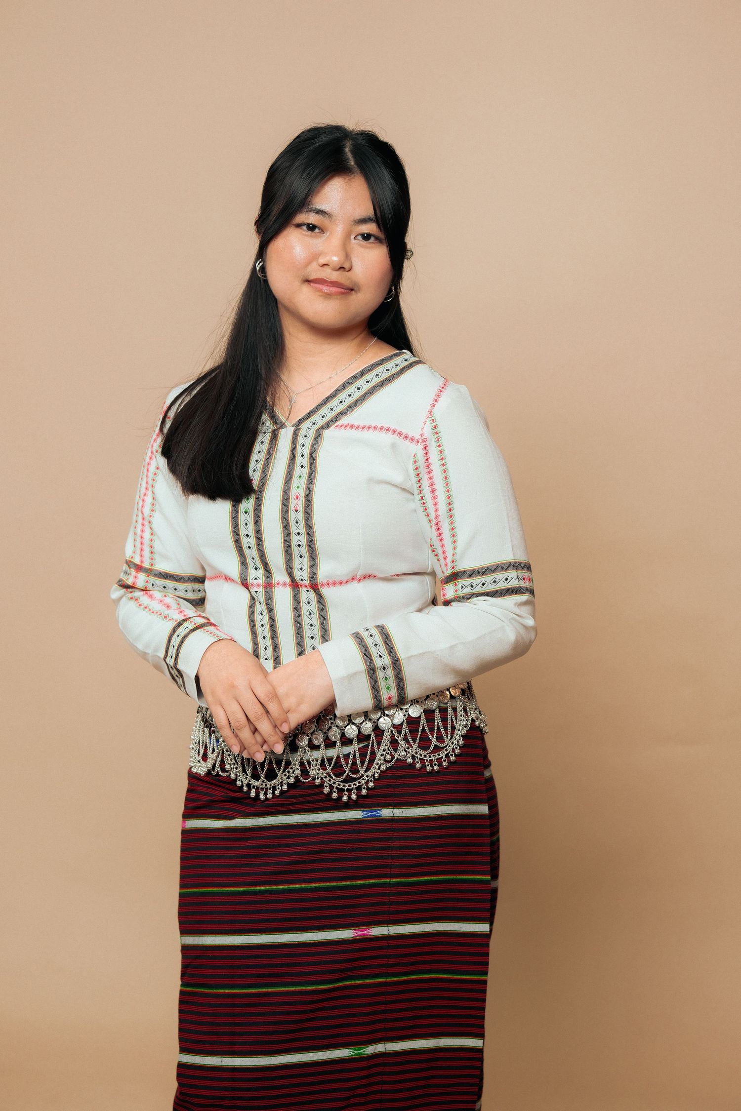 Model showcases traditional outfit with decorative metallic trim detail.