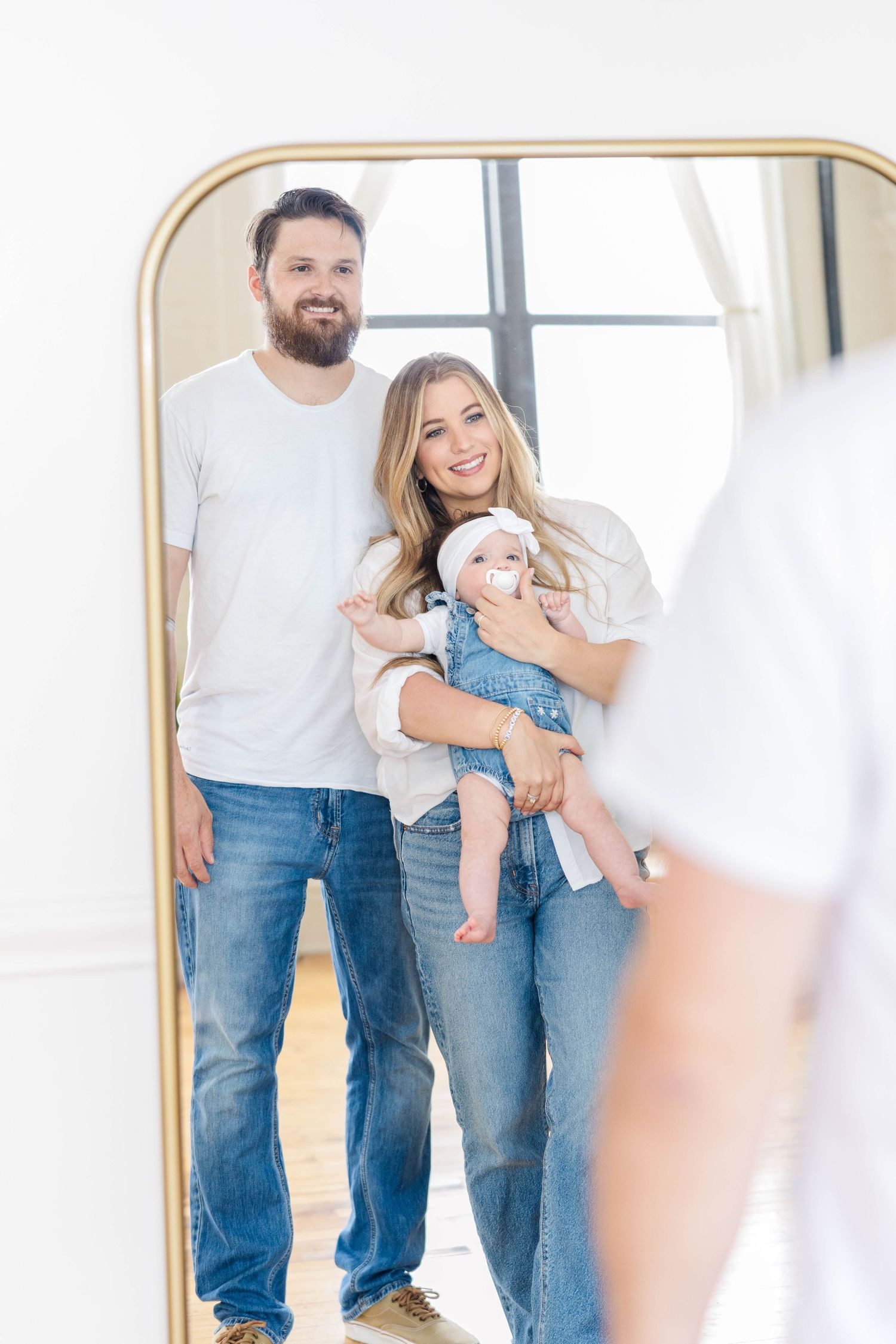Mom and dad smiling with baby between them during studio session at Gentle Bull Studios — Minmo Photography