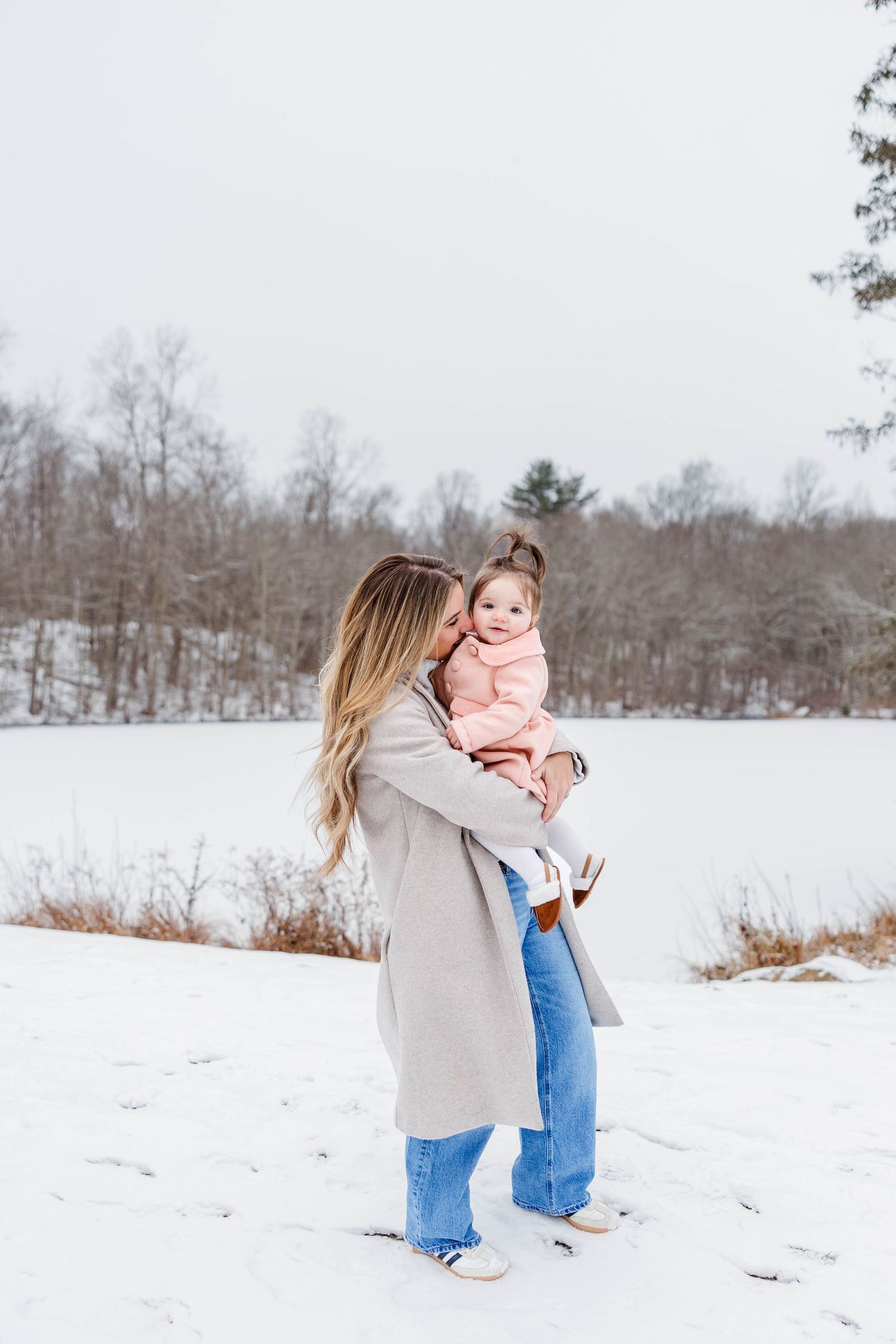Mom holding her daughter during a candid, winter Connecticut family photo session — Minmo Photography