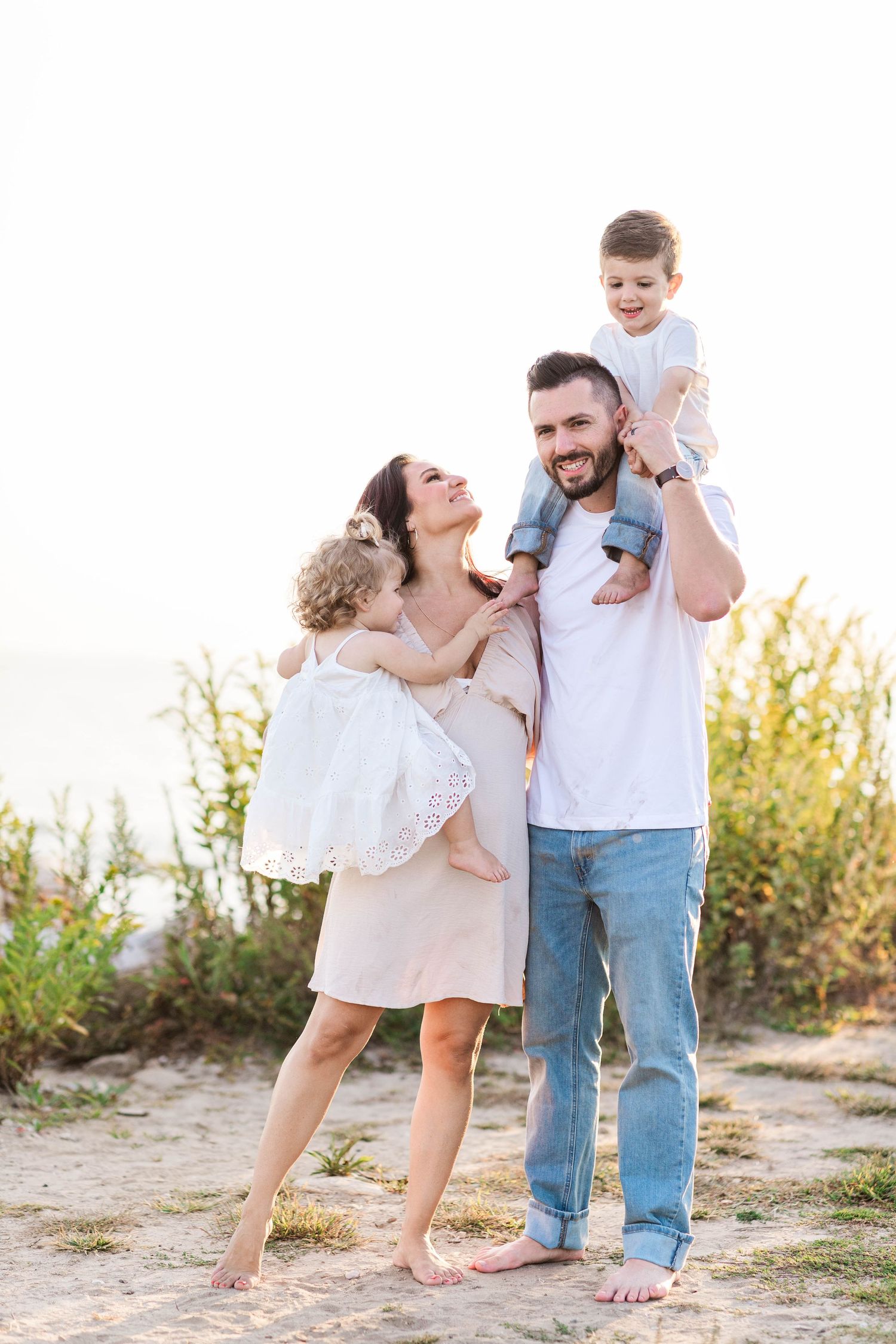 Family of four hugging at a Connecticut beach during a summer family session — Minmo Photography
