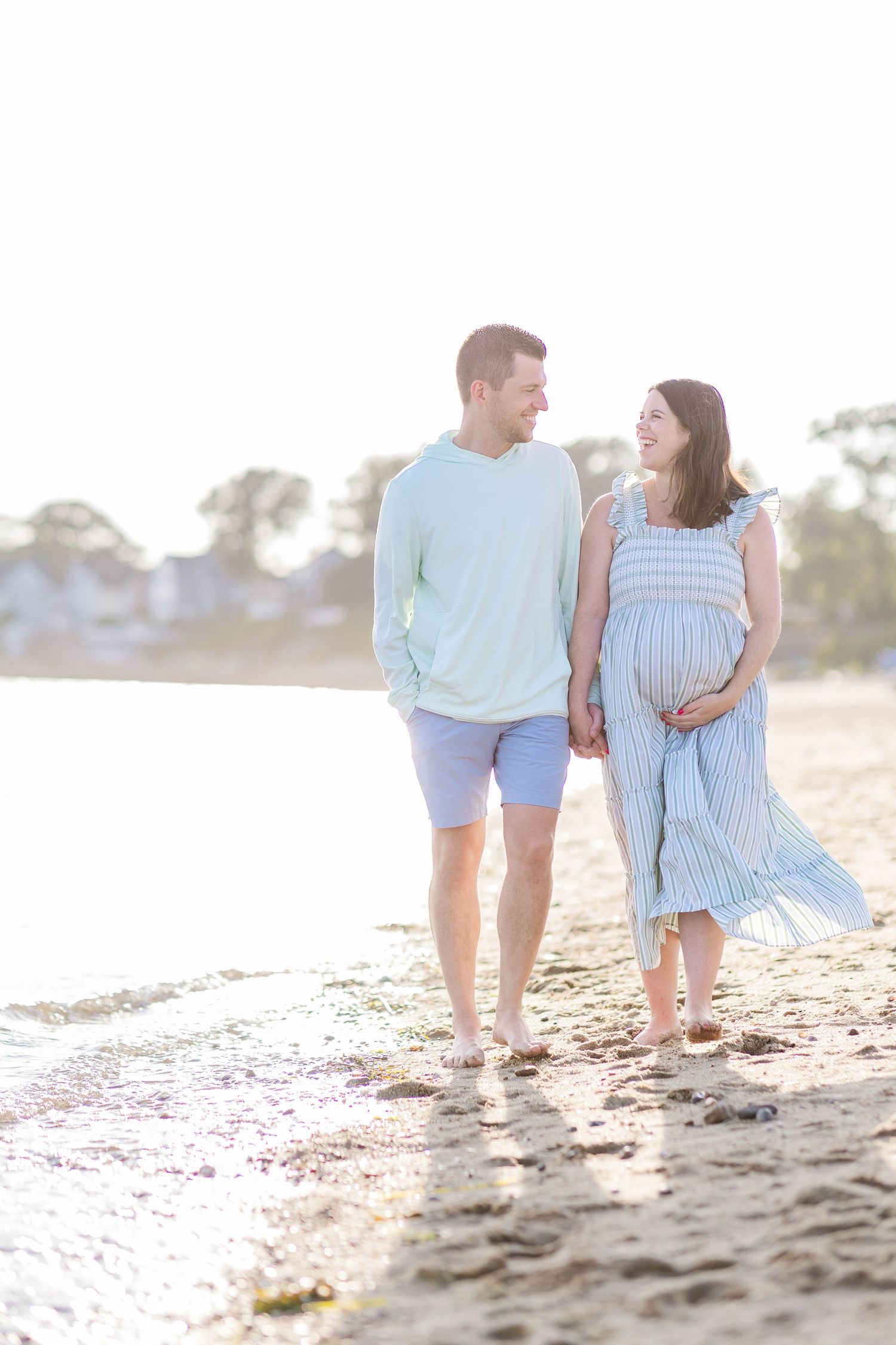Couple walking along the shore during a Connecticut maternity photography session outdoors — Minmo Photography