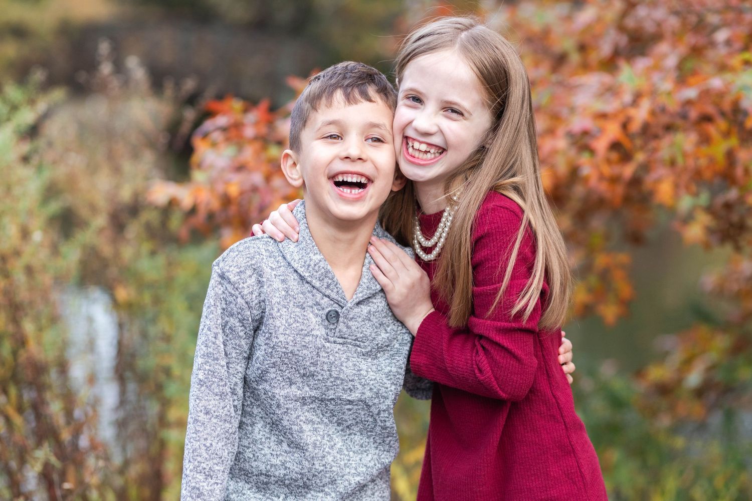 Two siblings laughing during a relaxed Connecticut portrait session in natural light — Minmo Photography