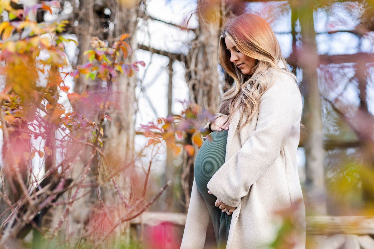 Pregnant woman cradling her belly during a Connecticut maternity session in natural light — Minmo Photography