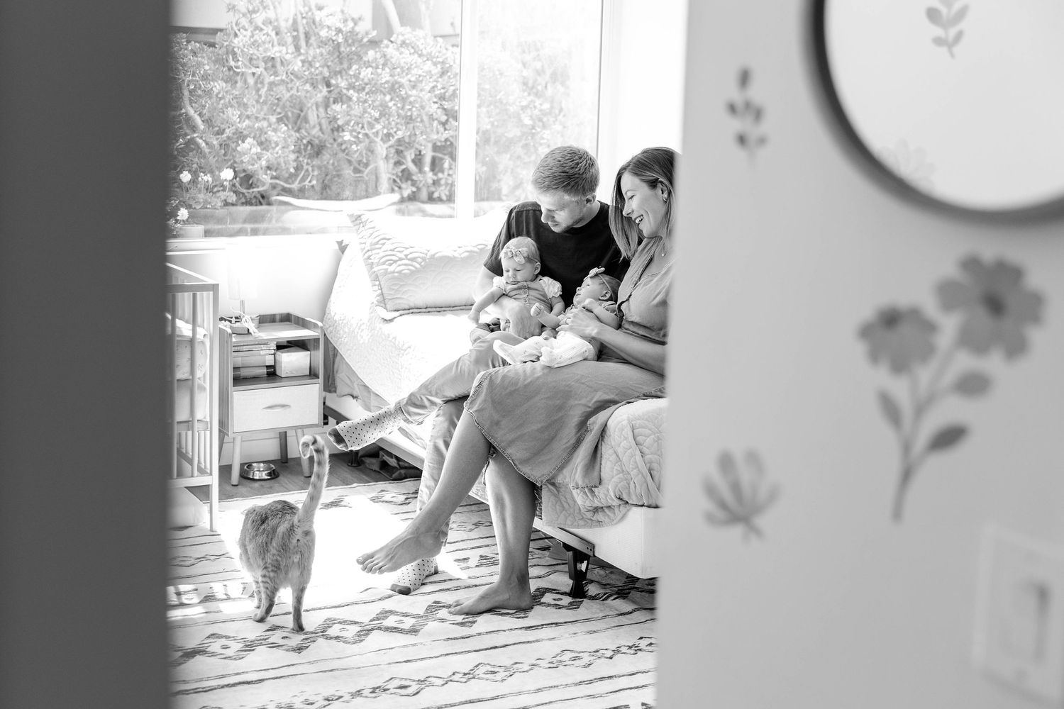 Mom and Dad showing their twin newborns to the family cats during a newborn session at home -- Minmo Photography