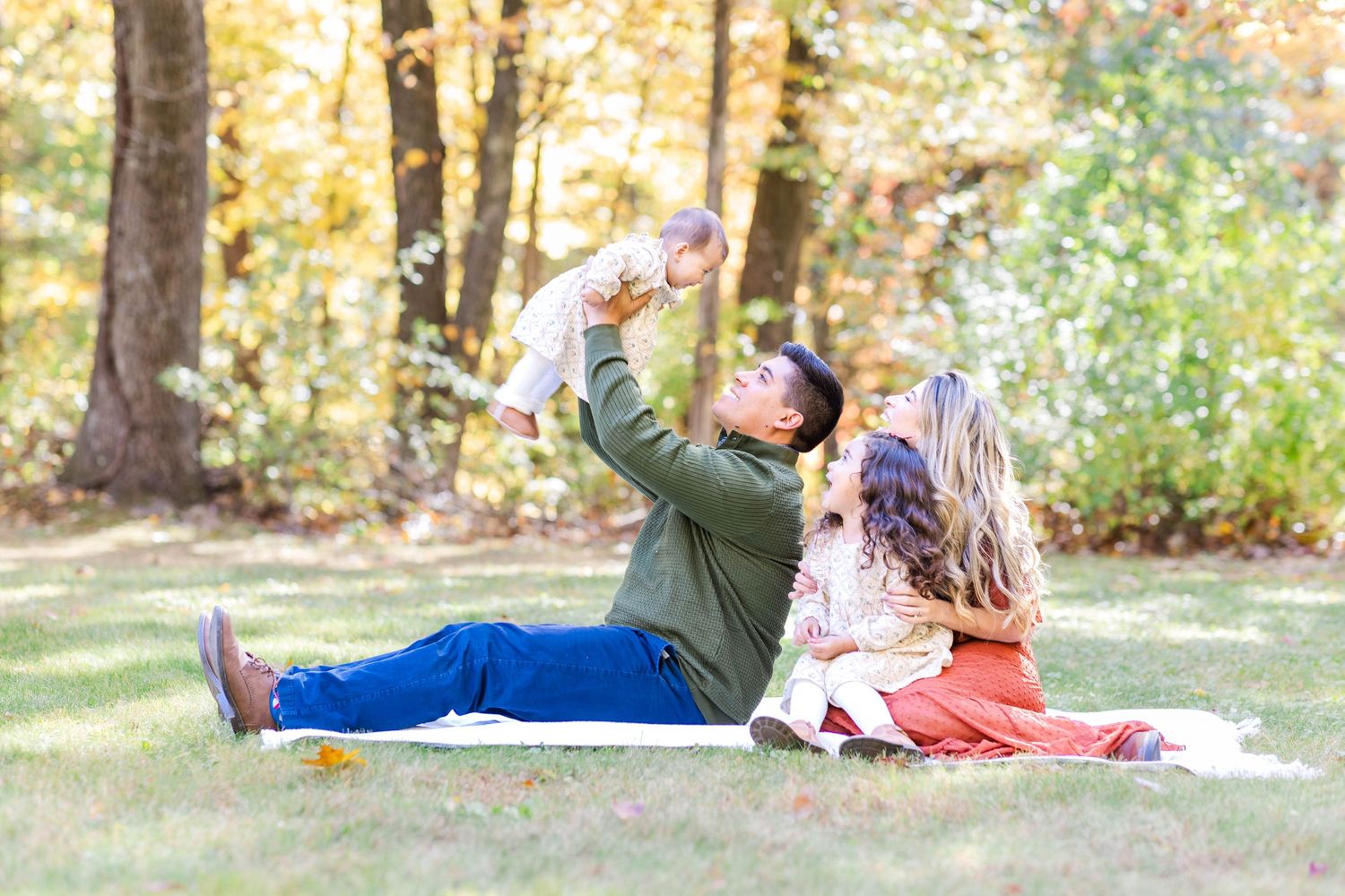 Family sitting together on a blanket during a golden hour Connecticut outdoor session — Minmo Photography
