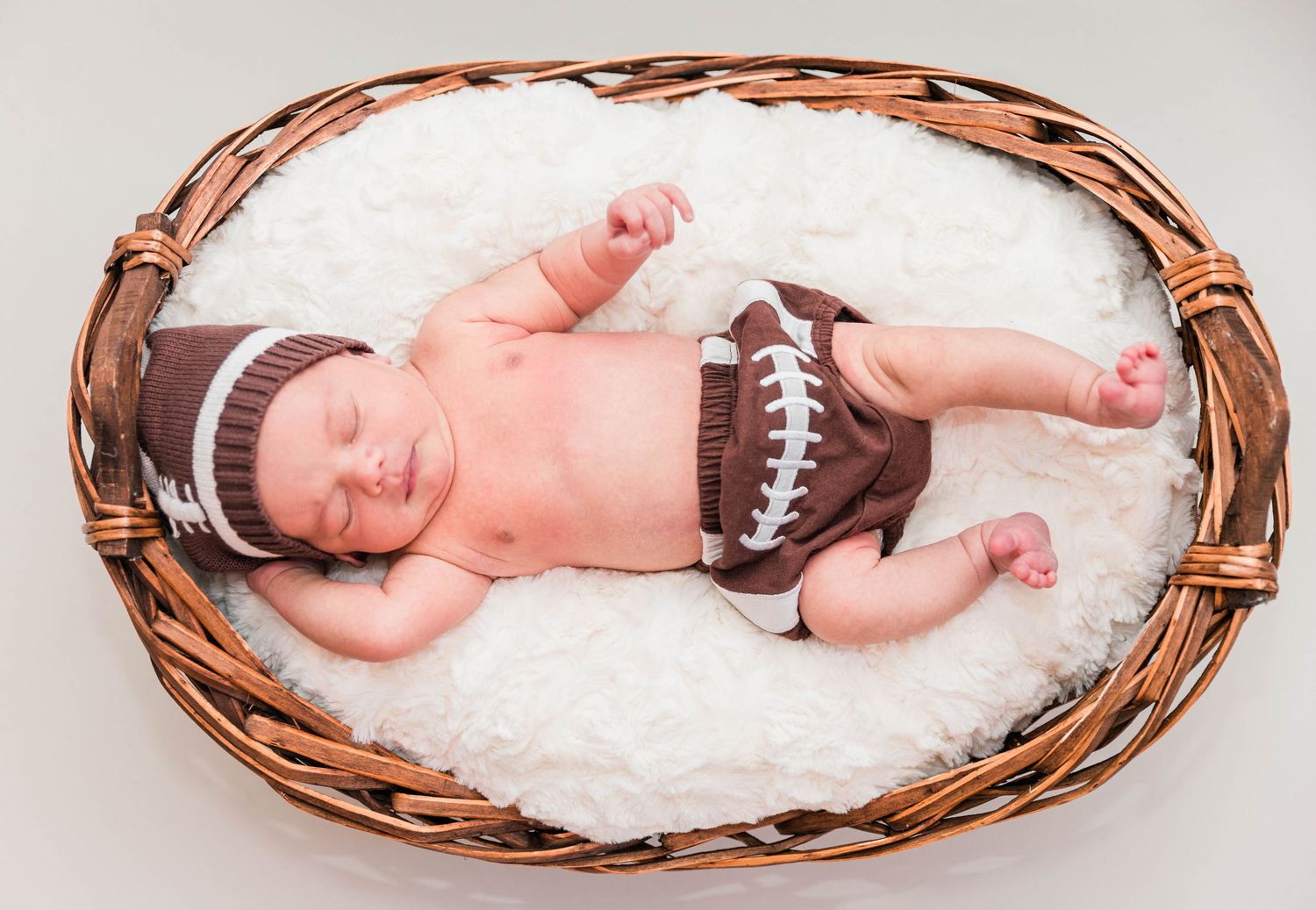 Newborn baby curled up in a basket during a Connecticut studio-style newborn session — Minmo Photography