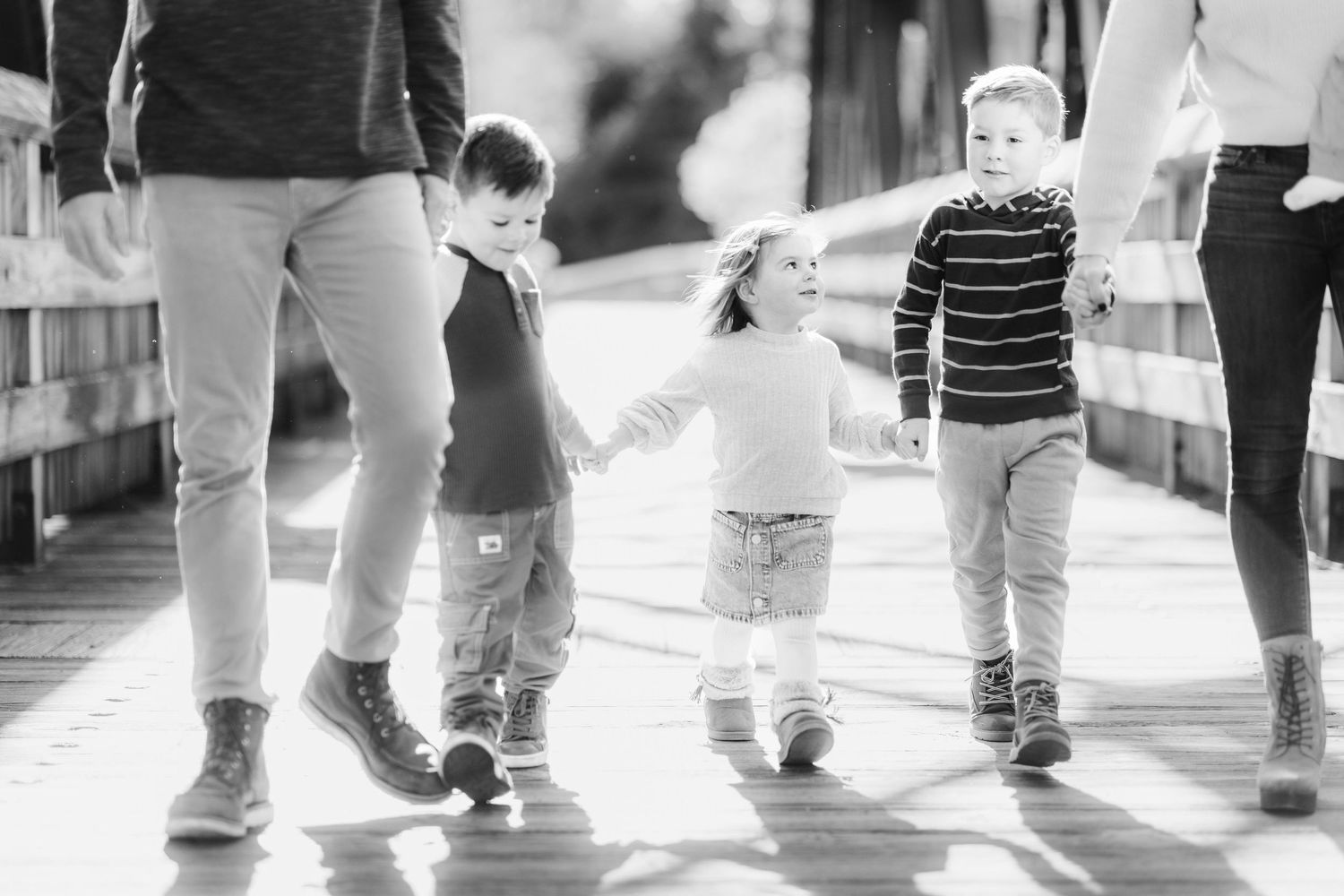 Close-up of siblings walking on bridge during golden hour family photoshoot -- Minmo Photography