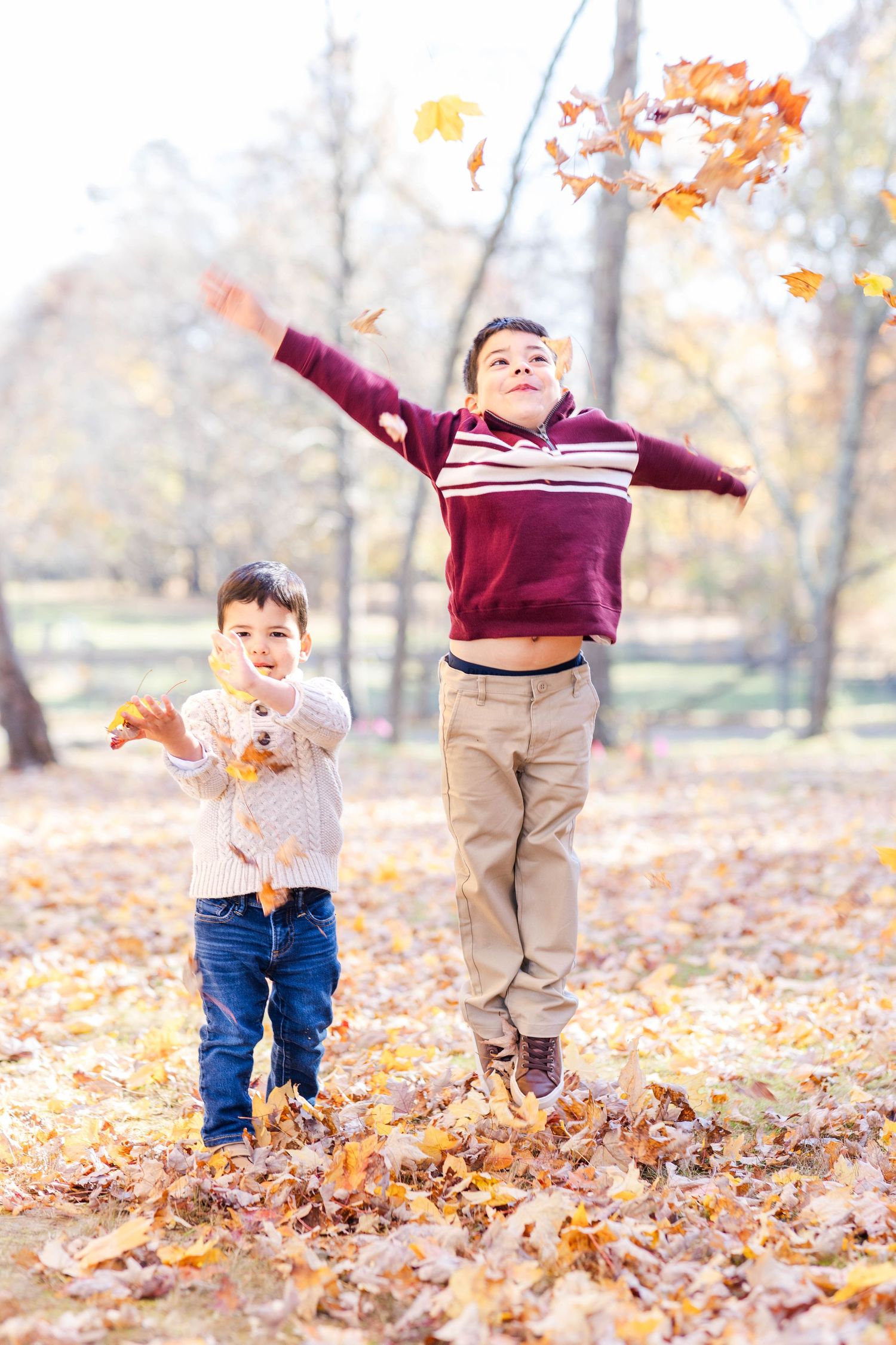 Two boys throwing leaves during fun and candid family photoshoot at Westmoor Park -- Minmo Photography