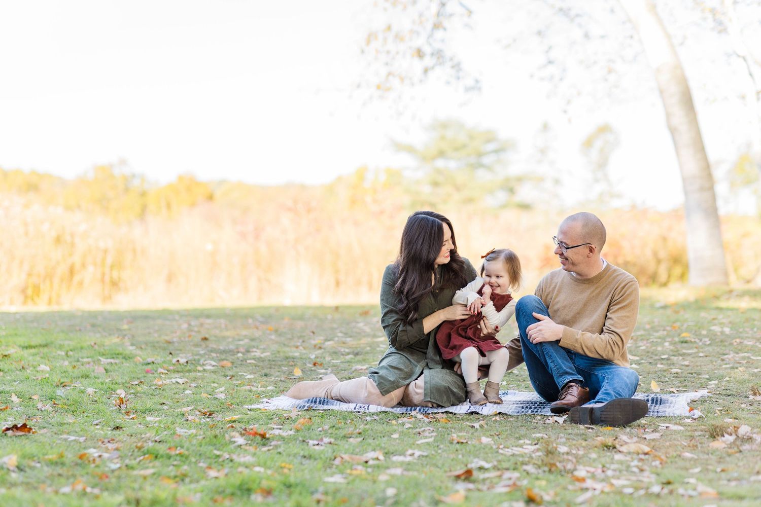 Family sitting together on a blanket during a golden hour Connecticut outdoor session at Westmoor Park — Minmo Photography