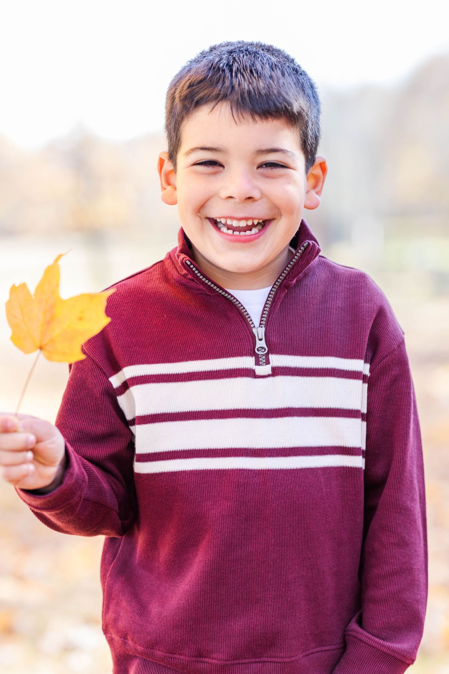 Close-up portrait of a toddler in natural light surrounded by leaves — Connecticut portrait photographer Minmo Photography