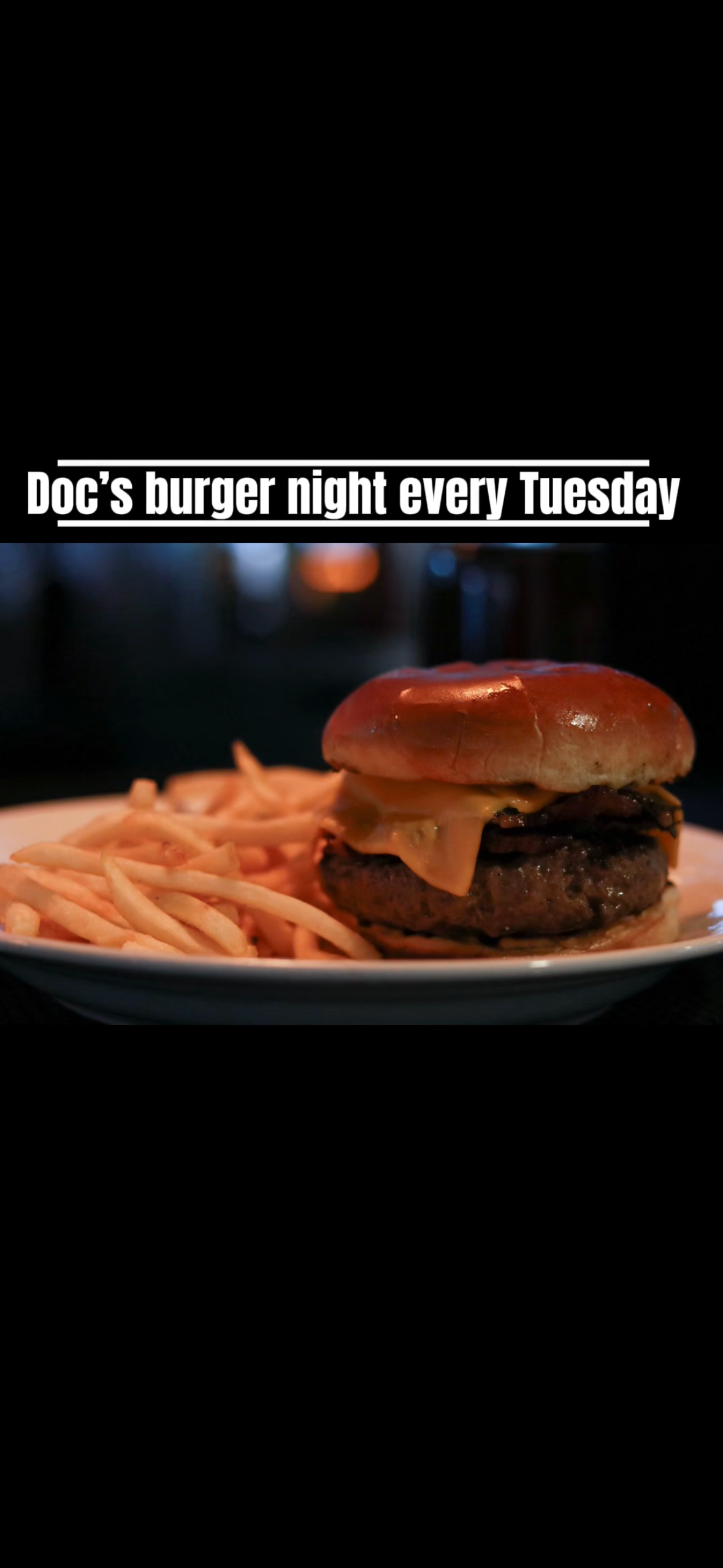 A close-up shot of juicy hamburgers with french fries on dark plates advertising Doc's burger night every Tuesday.
