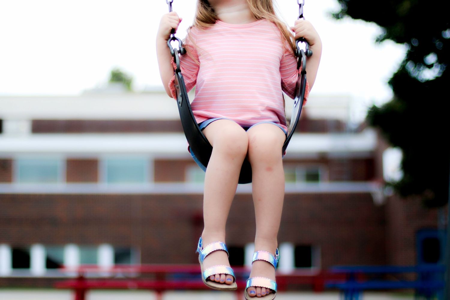 A collage of images showing a child on a playground swing wearing pink clothing and white sandals.