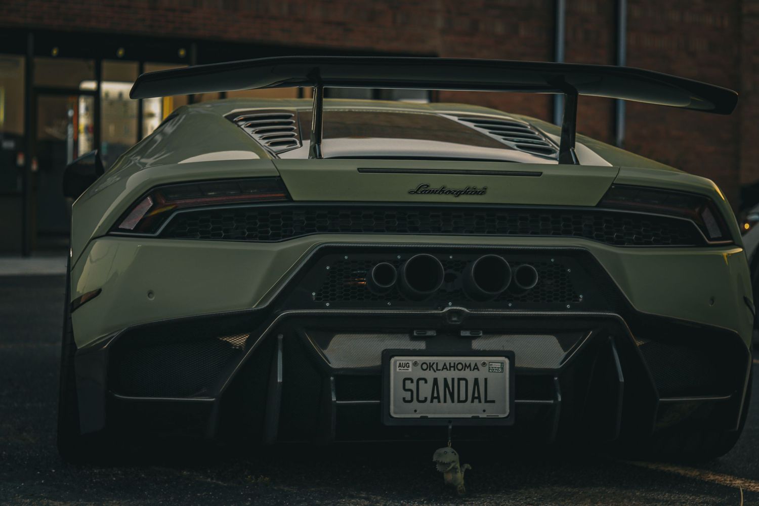Low angle shot of a white Lamborghini's rear end showing aggressive styling and exhaust details.