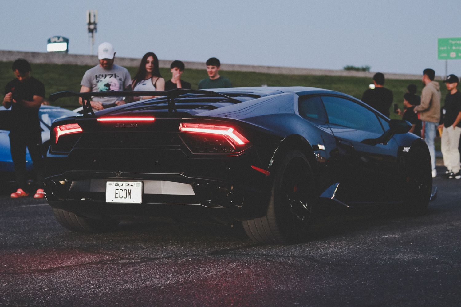Collection of performance cars lined up at sunset with dramatic lighting.