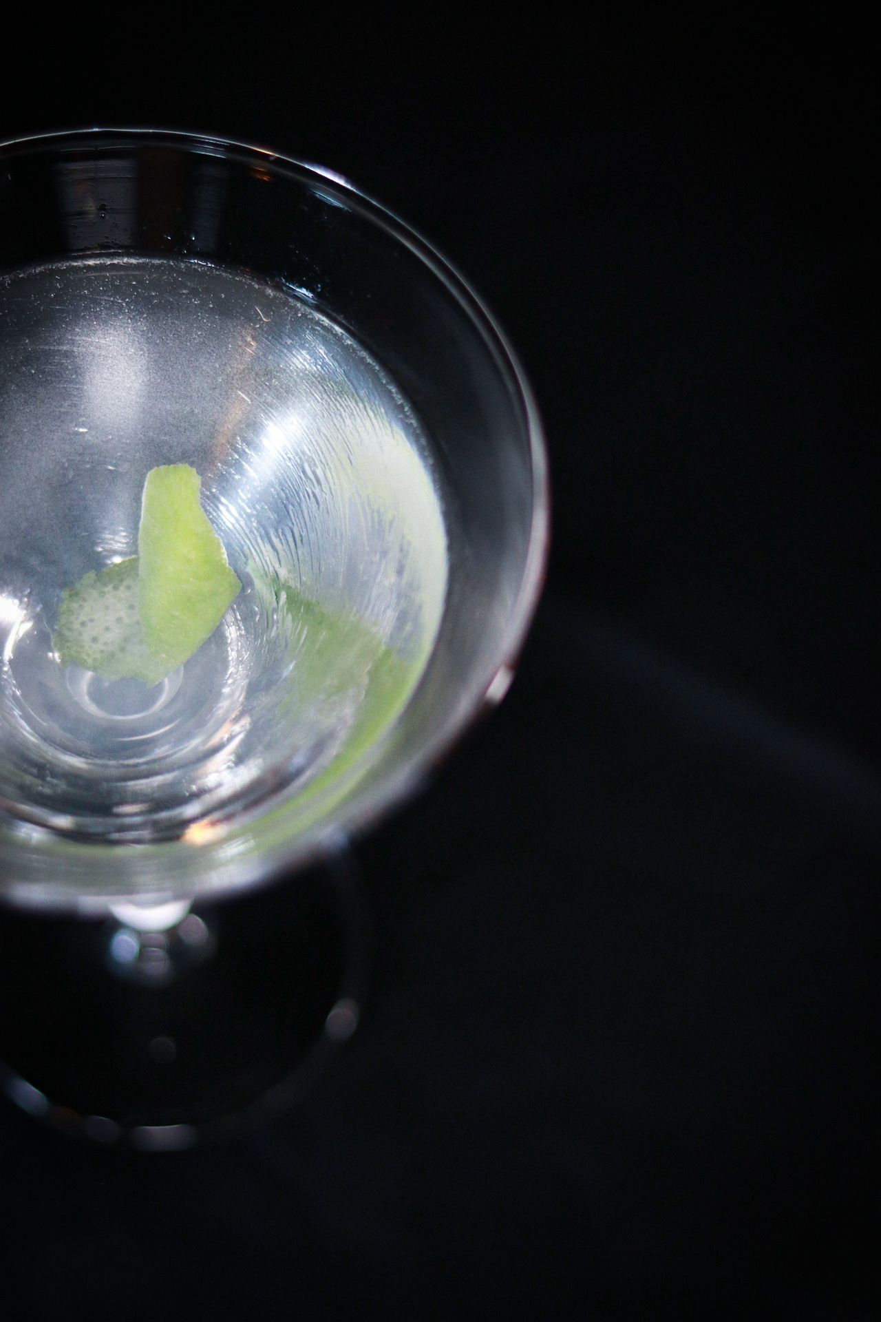 Close-up sequence of martini glass rim with lime garnish in low light.