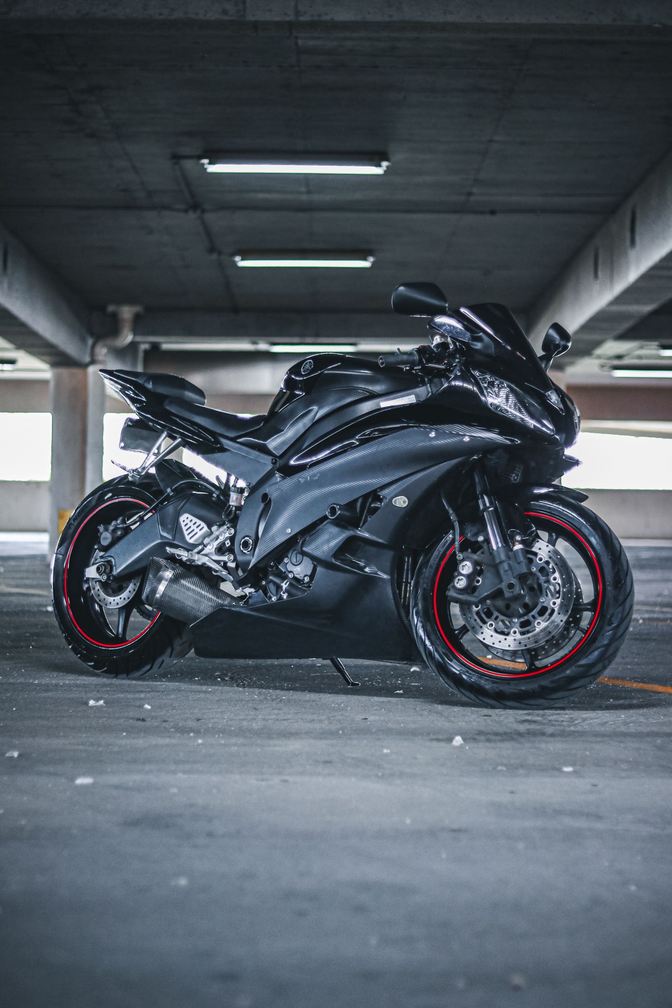 Black sports motorcycles parked in sequence showing different angles in a garage setting.