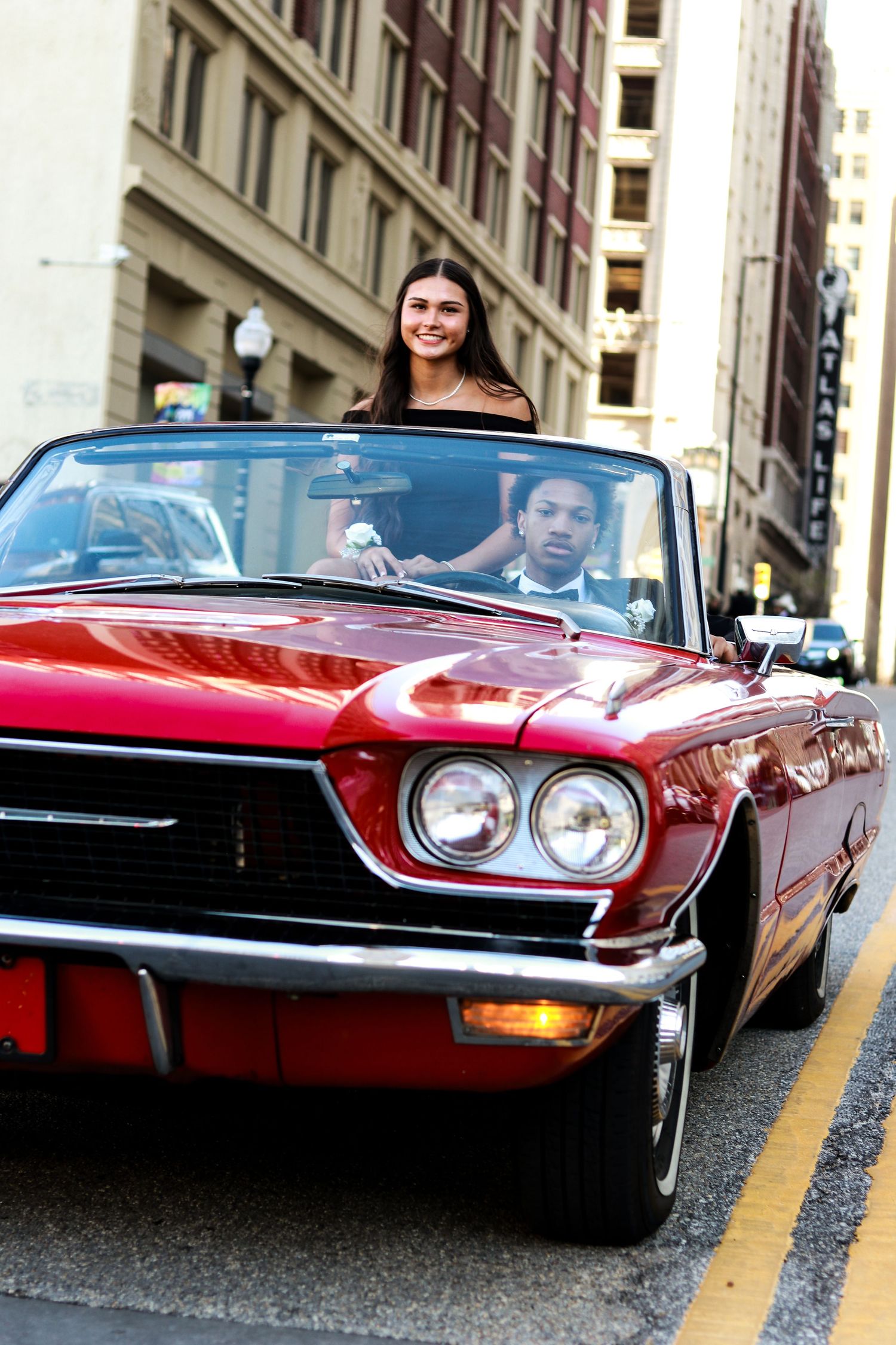 A classic red convertible sports car shown from multiple angles parked on a city street.