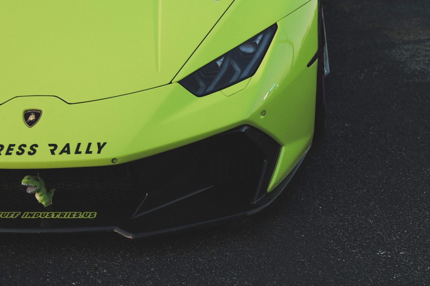 A bright neon green sports car with black accents is displayed against a dark background.