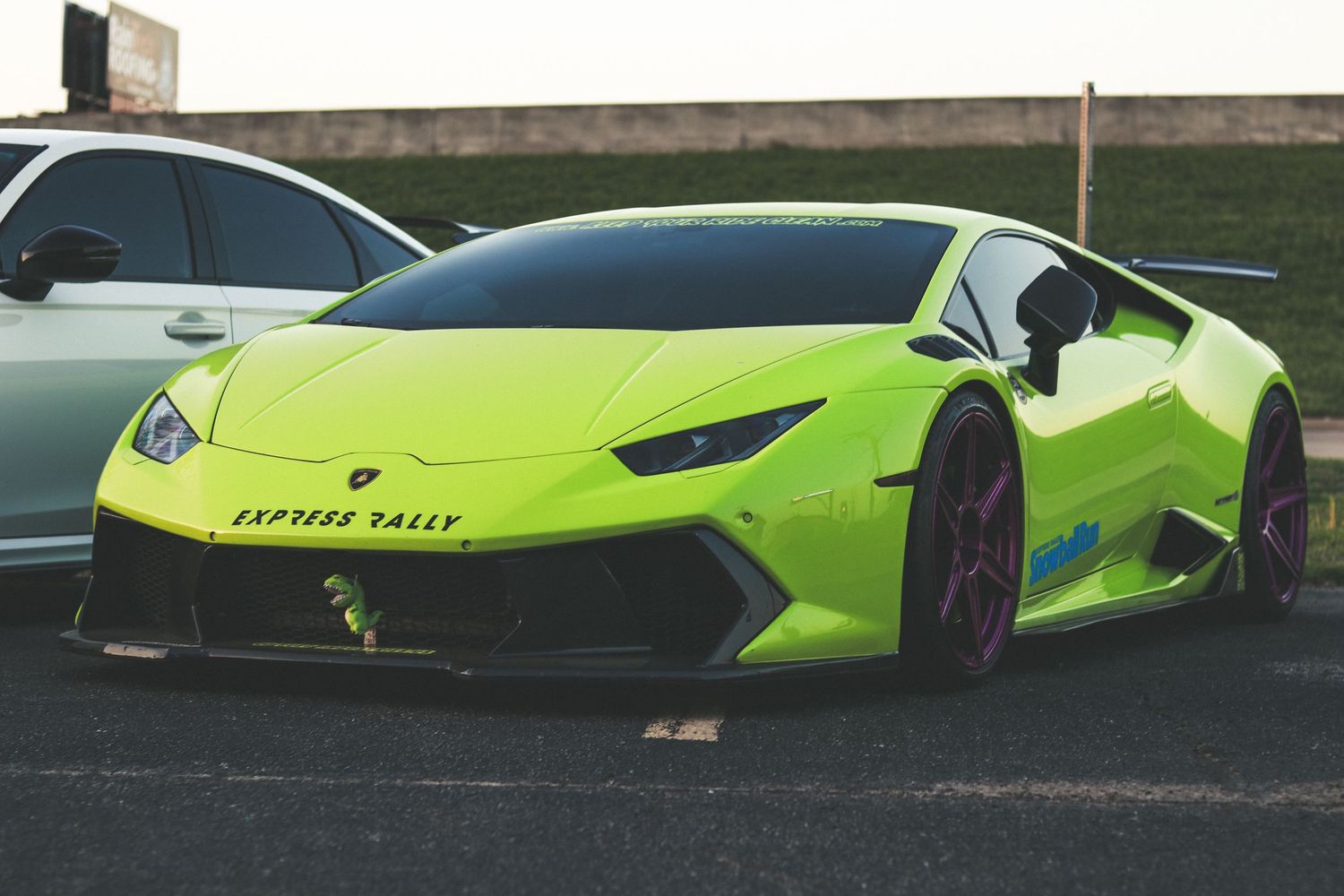 Side profile view of a lime green Lamborghini supercar parked outdoors.