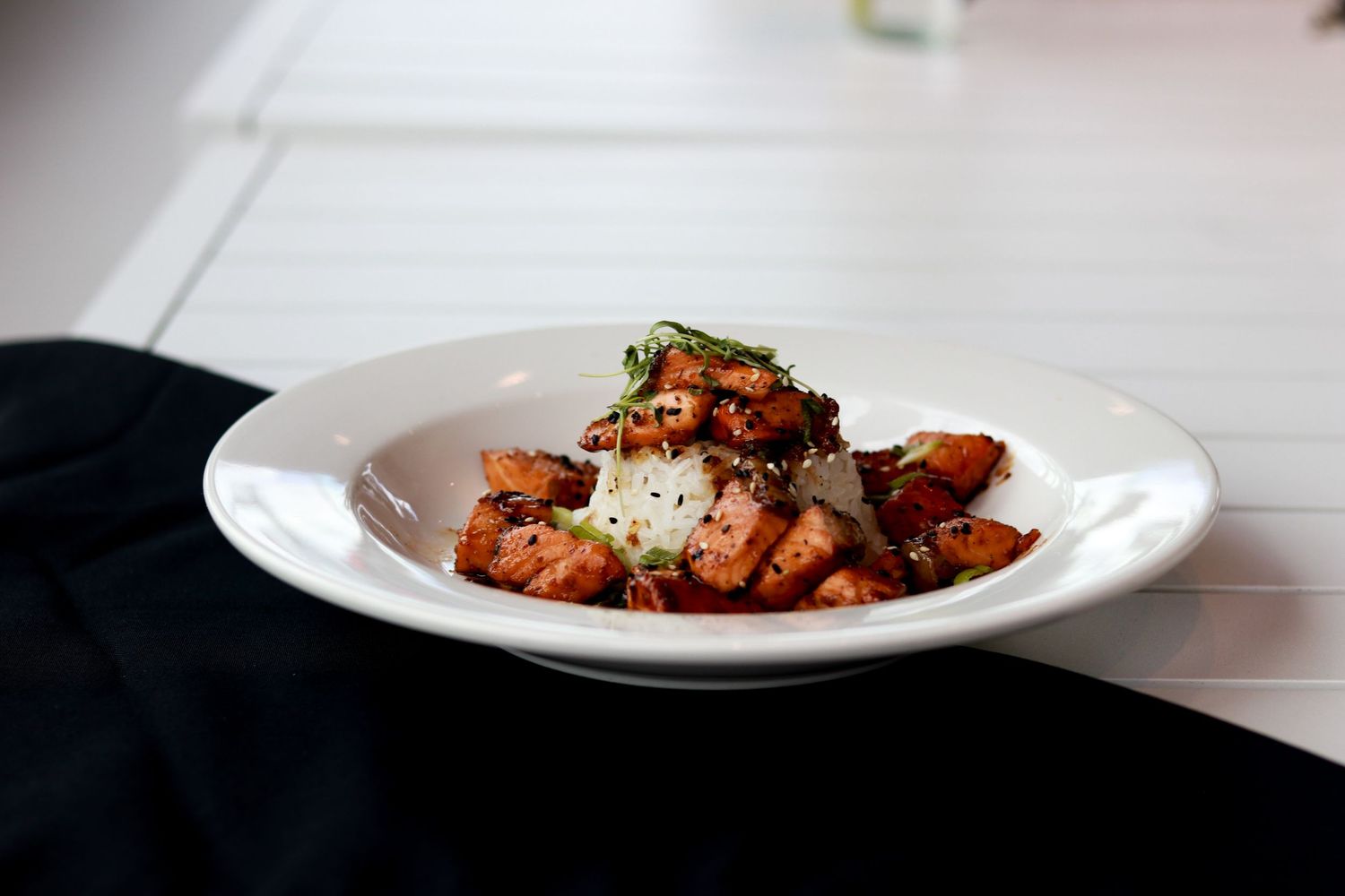 Plated dishes of gourmet food arranged in a row showcase various elegant restaurant entrees and appetizers.