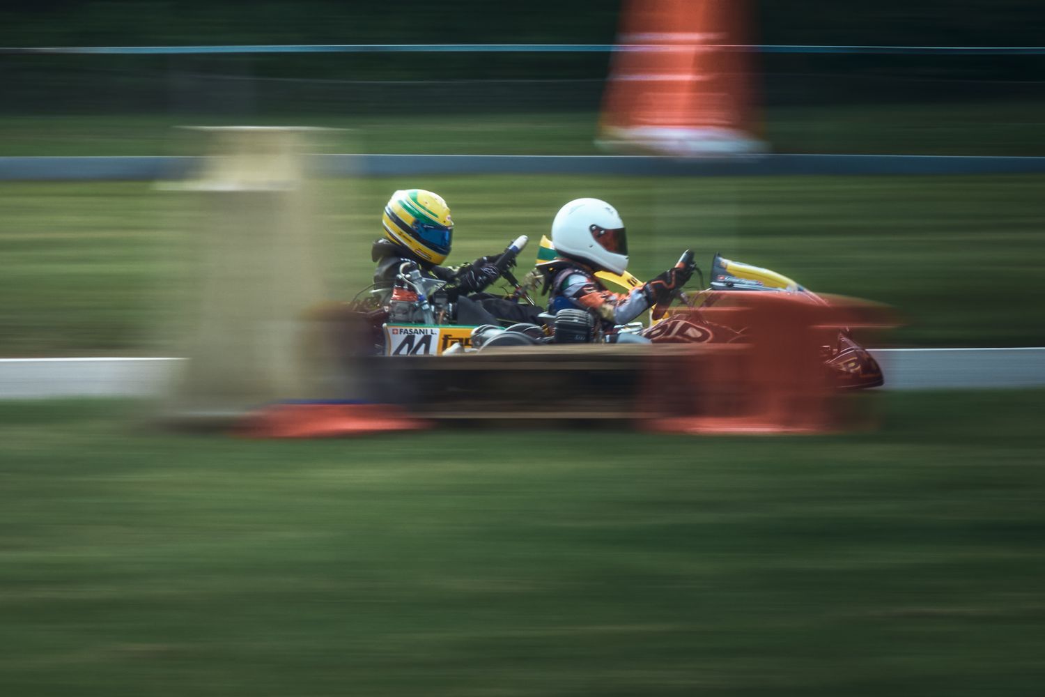 Fotografia d’azione durante una gara di kart con due piloti in lotta per la posizione in pista