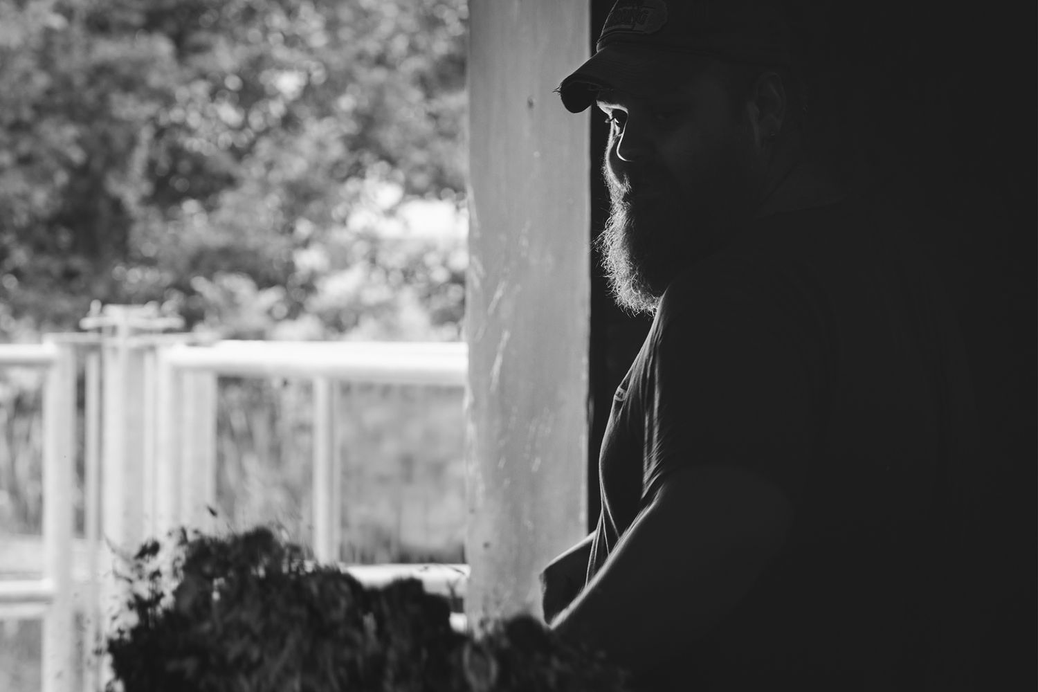 Persona al lavoro in bianco e nero, gesto concentrato e luce radente che evidenzia mani, strumenti e la materia del mestiere.