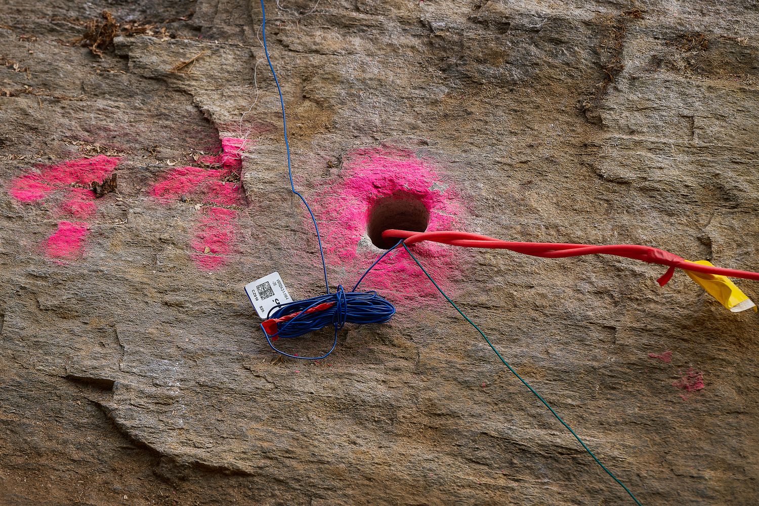 Fotografia di perforazioni numerate su roccia in fase di preparazione per lavori di scavo controllato