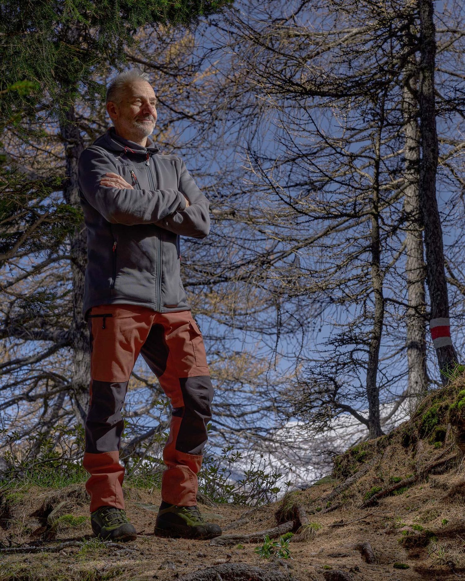 Ritratto nel bosco sotto la luce autunnale. Uno sguardo attento che racconta il legame tra uomo, luogo e luce.