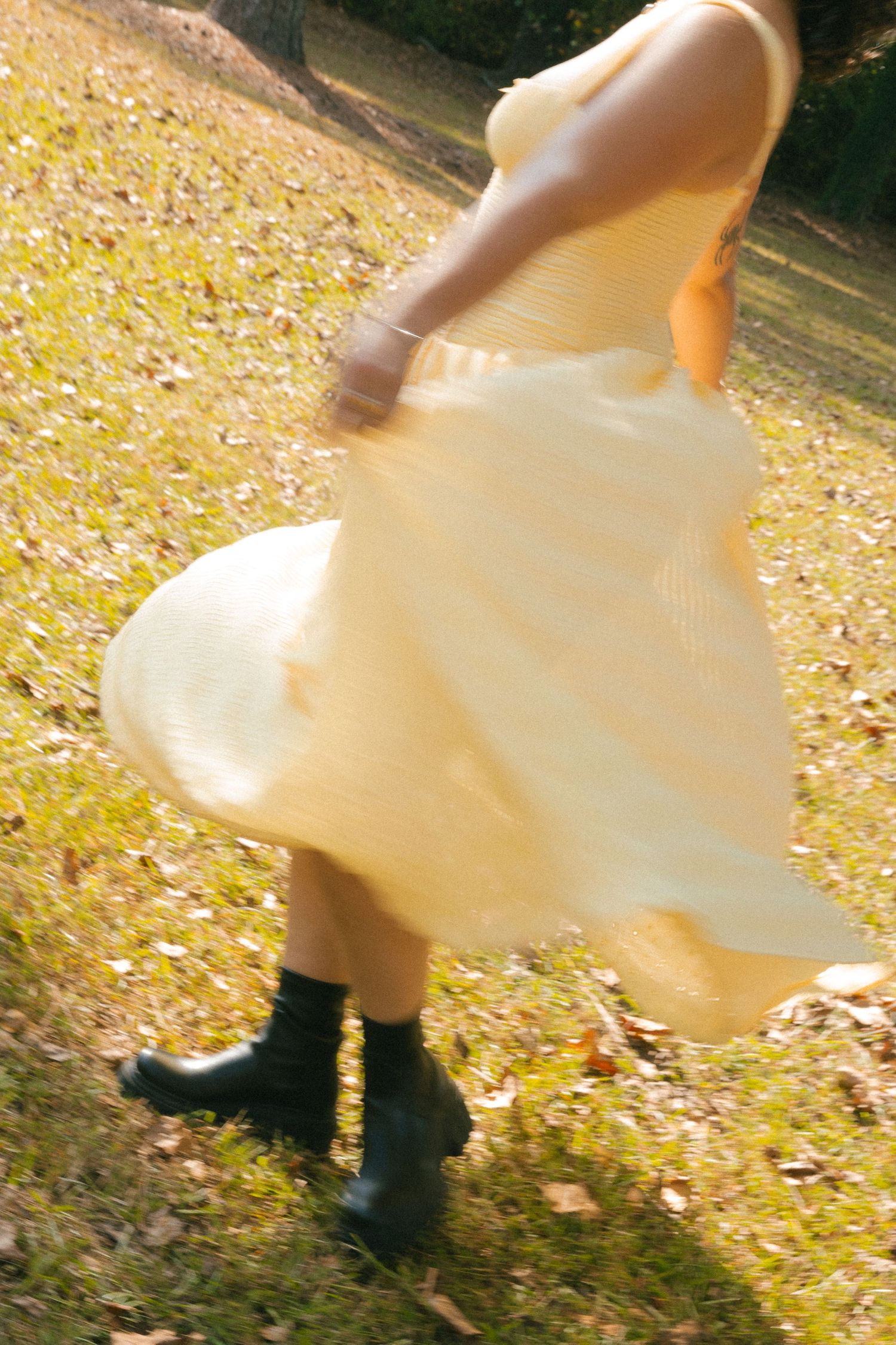 yellow flowy dress in the park in fall, motion blur and romantic feeling