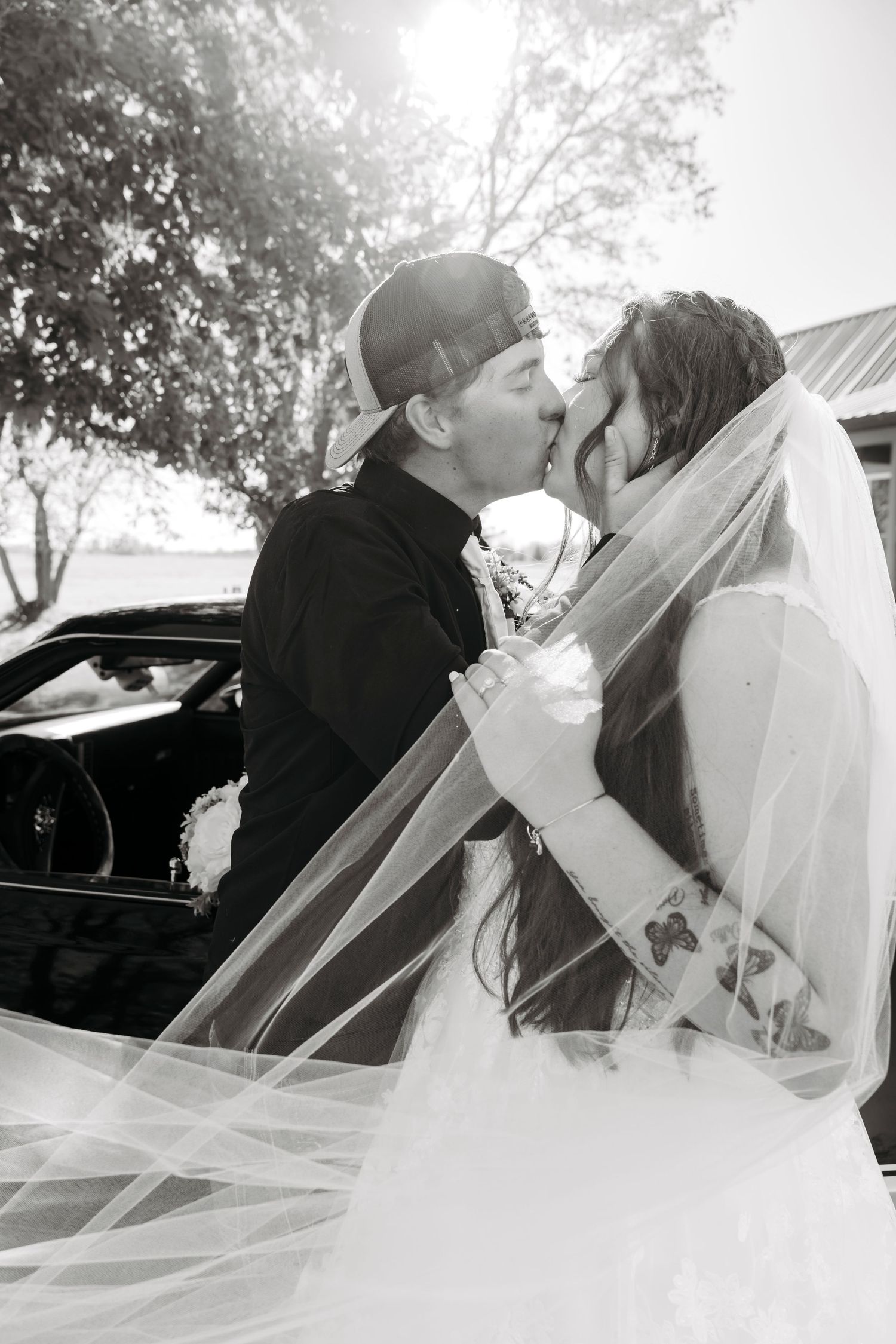 Black and white wedding photos of the bride and the groom next to a vintage car