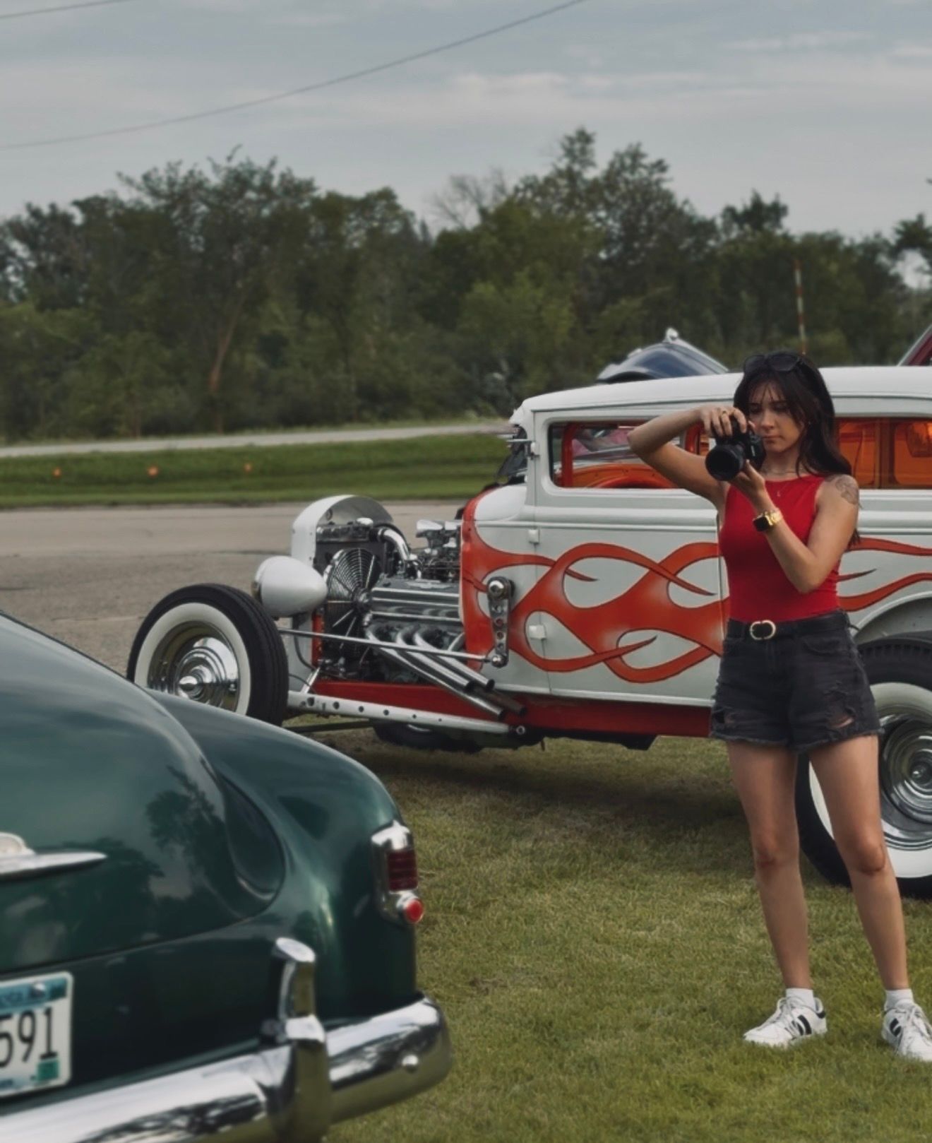 A BTS photo of the owner of Coley Rose Co. at a car show next to a vintage car for Mid Minnesota Motor Head.