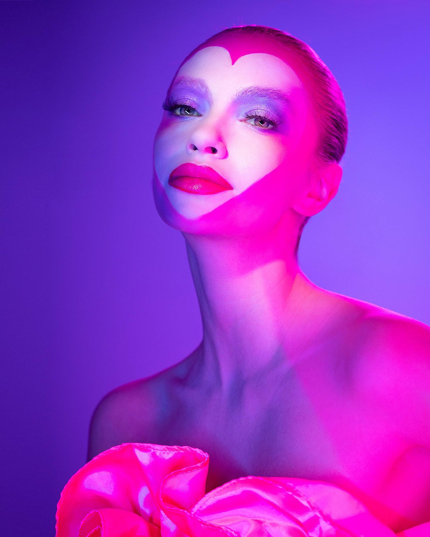 Artistic beauty portrait with dramatic pink and purple lighting effects.