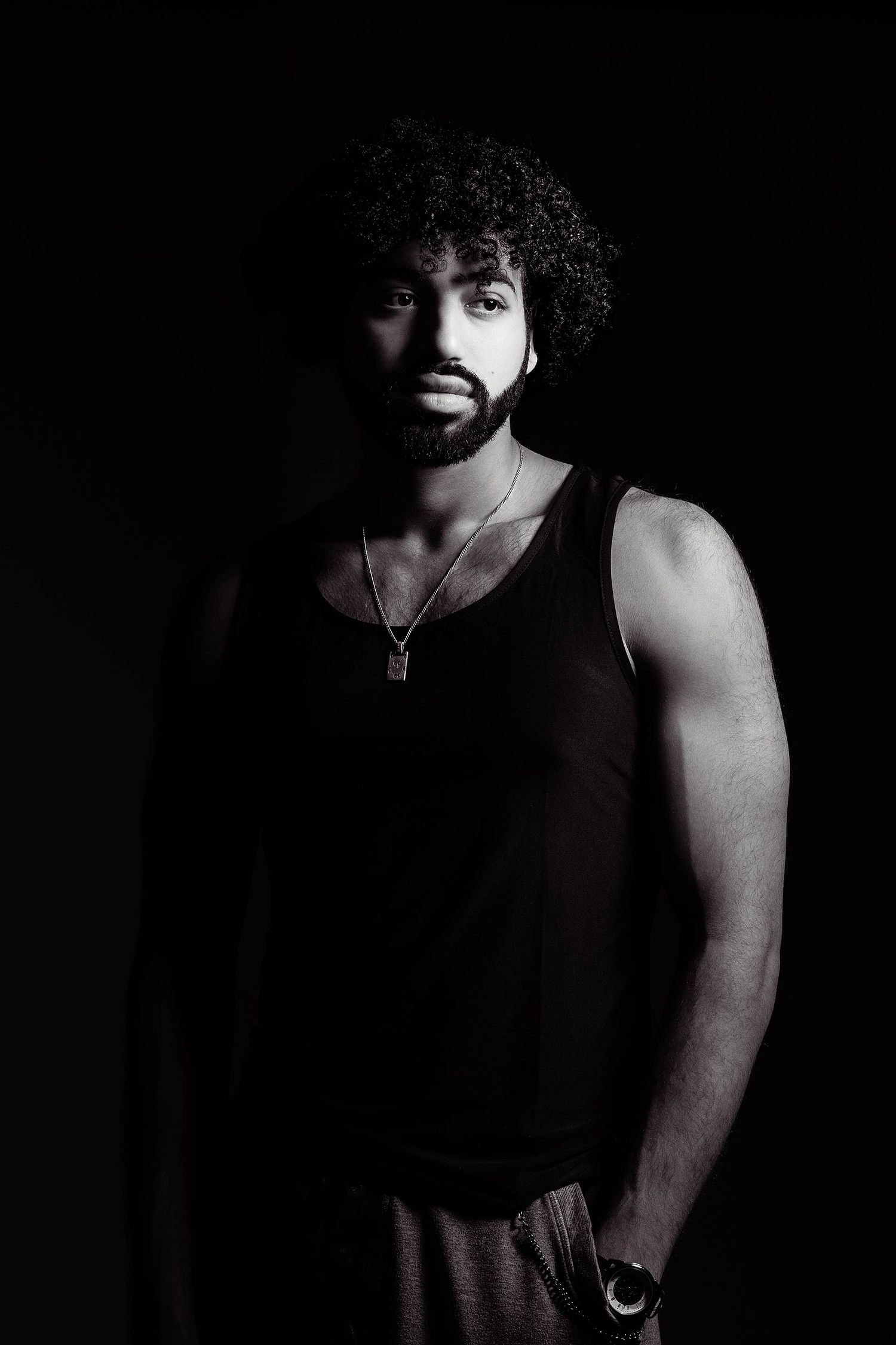 Artistic black and white portrait featuring silhouetted figure in darkness.