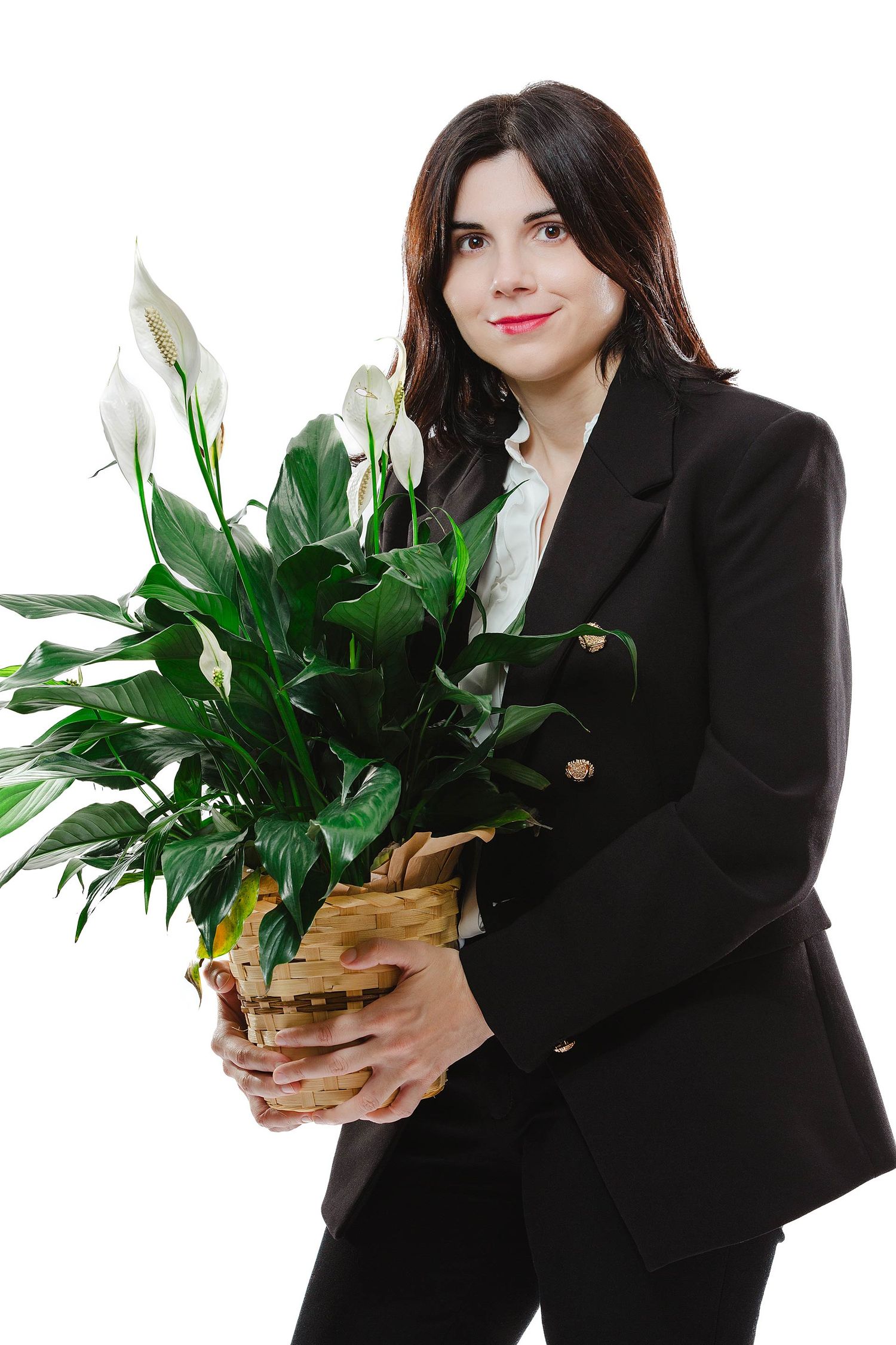 Business professional holding decorative peace lily plant in studio setting.
