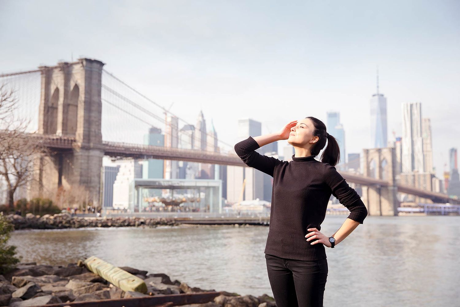 Dance-inspired poses captured near Brooklyn Bridge with Manhattan skyline view.