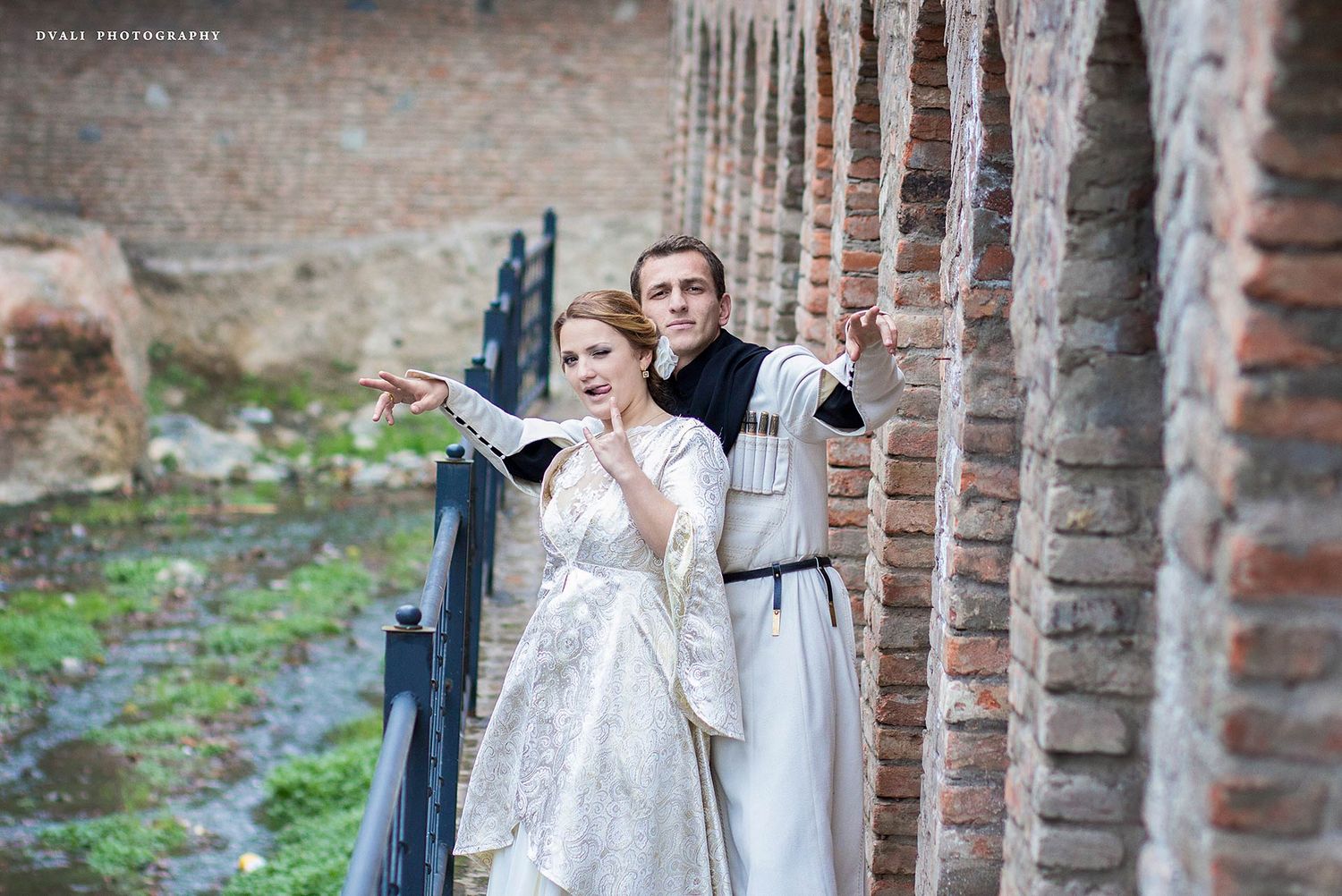 Wedding portraits taken against rustic brick archways and columns.