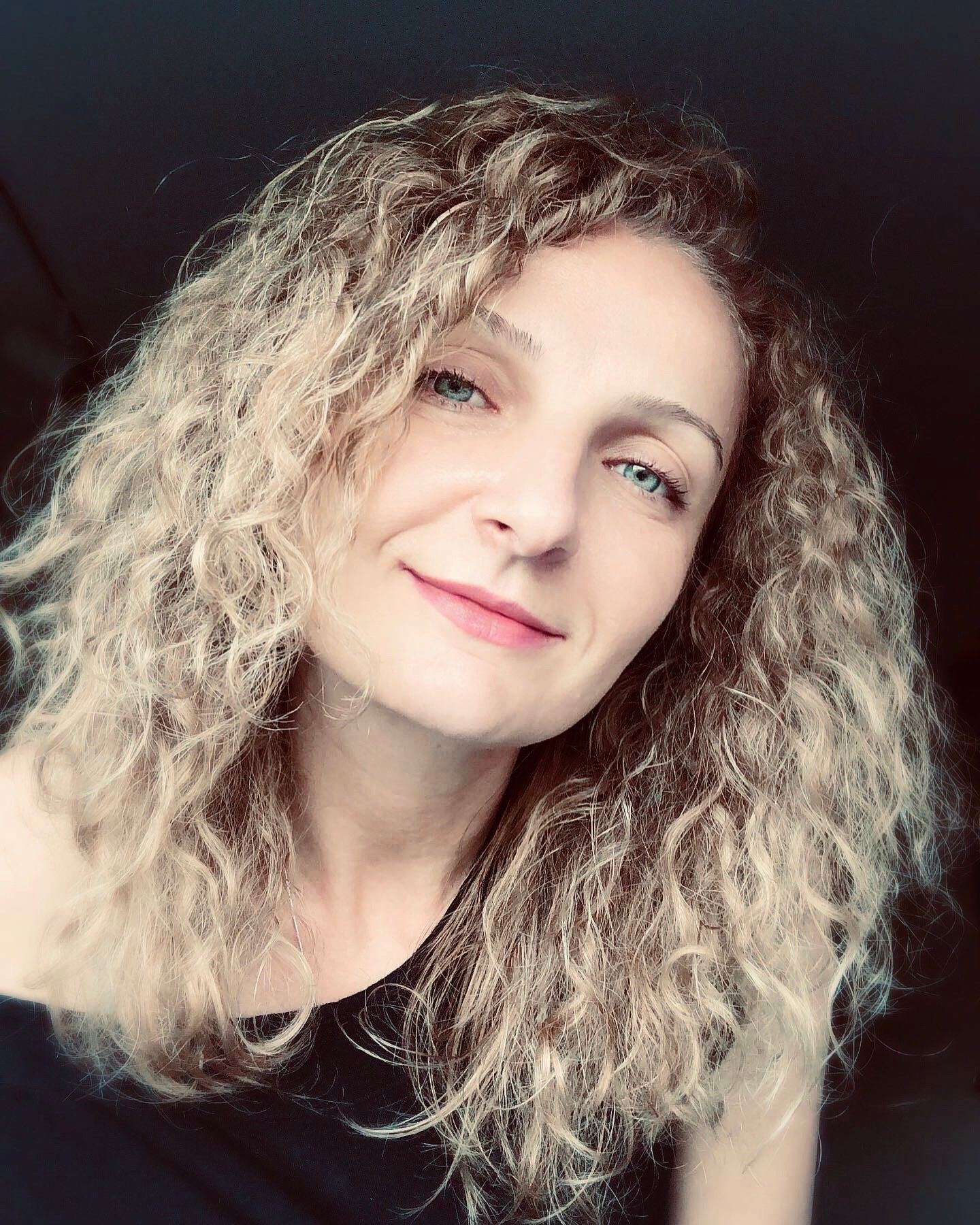 Series of selfies showing curly blonde hair and natural makeup against dark background.