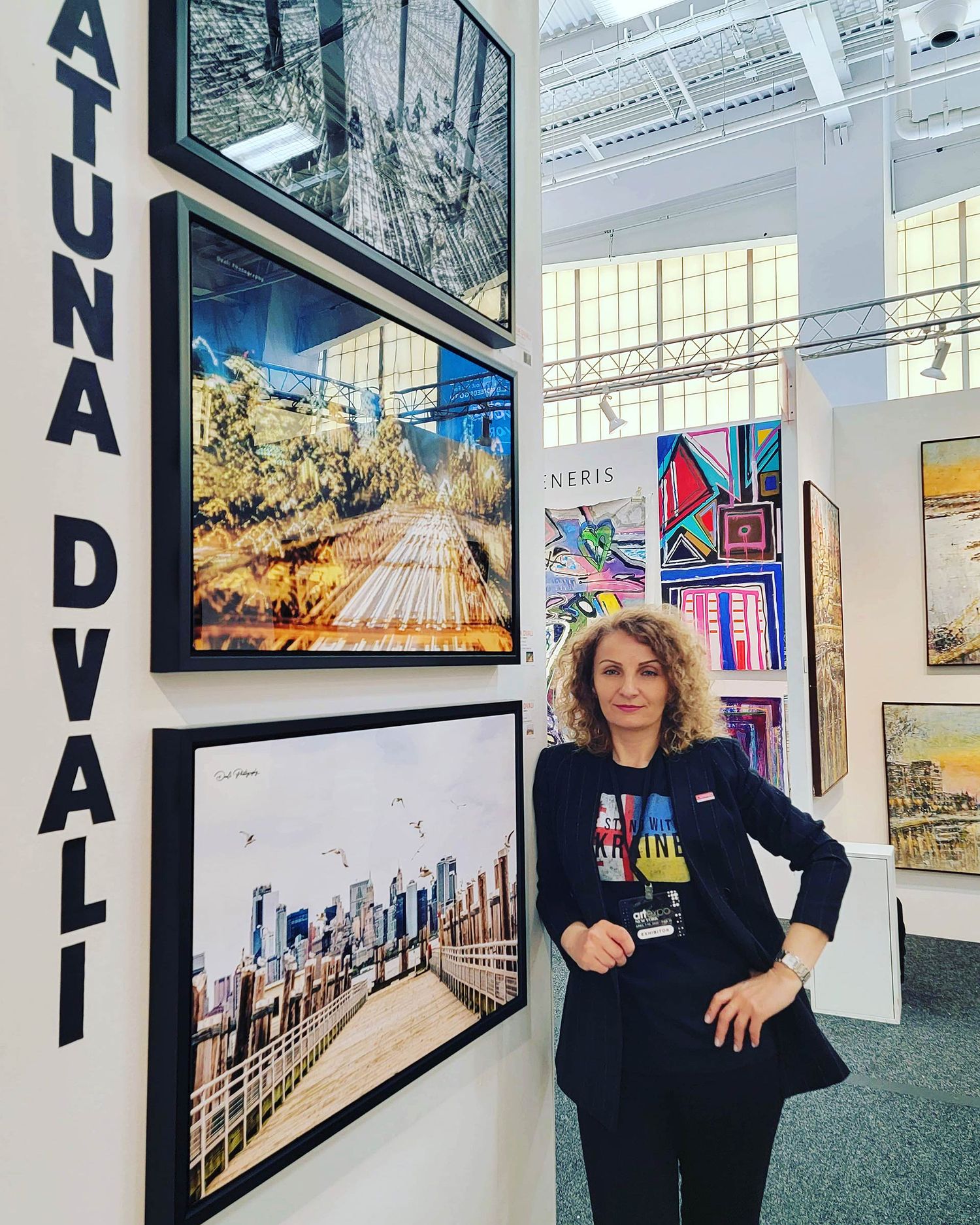 Art gallery interior showing urban photography displays and signage for 'ATUNA DVALI'.